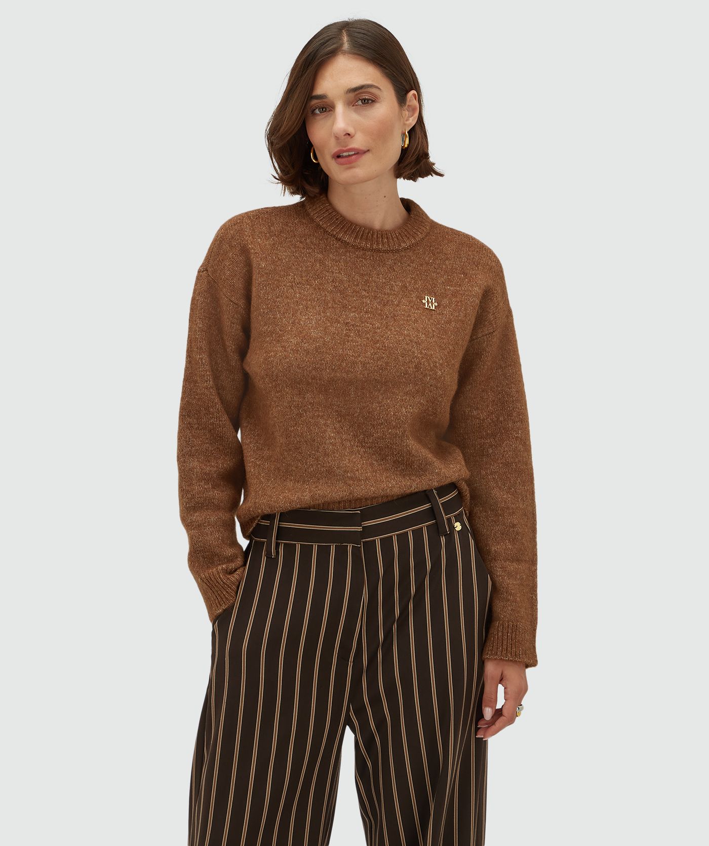 Model draagt een mid rise wide leg pantalon met strepen