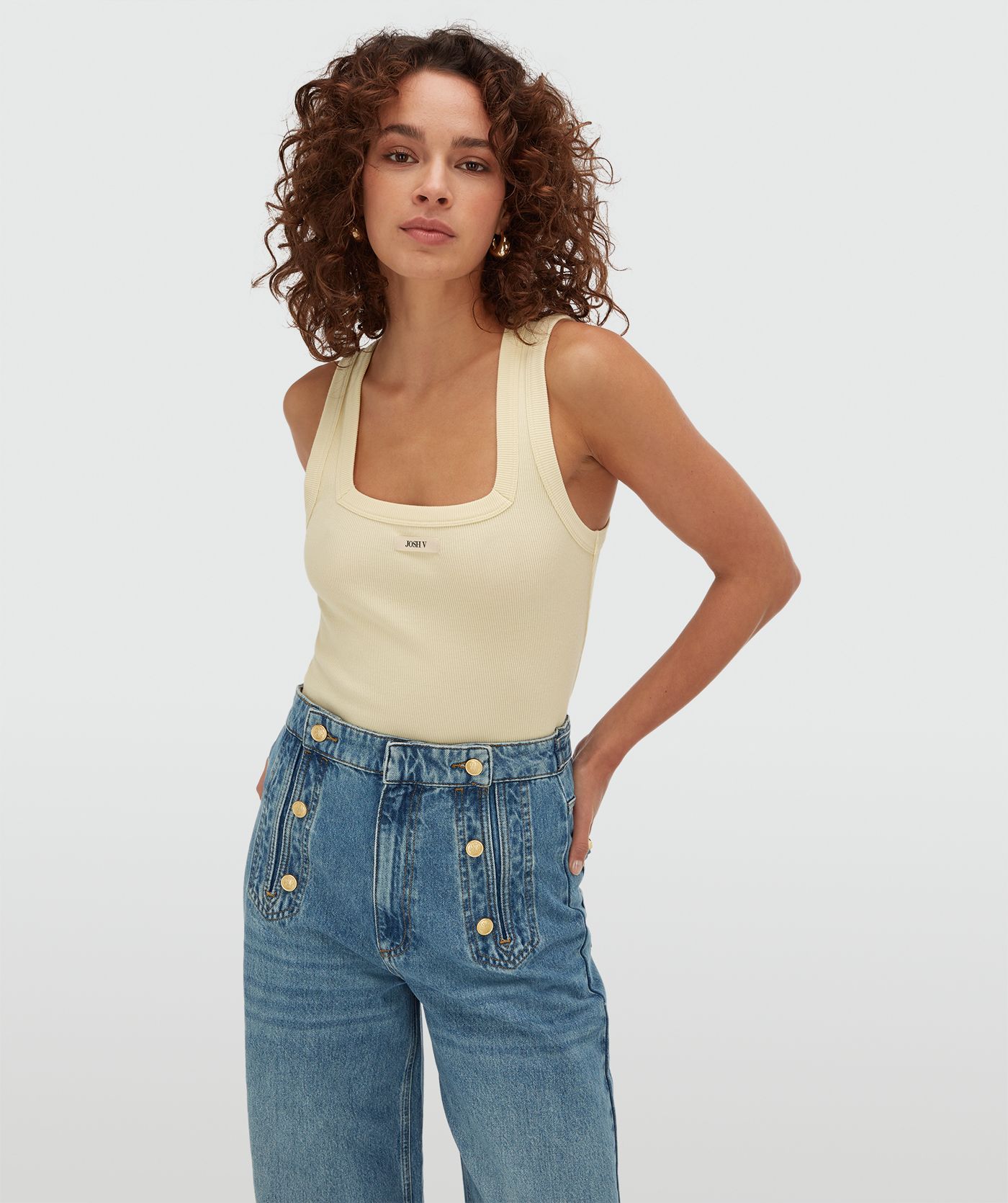 Model draagt een slim fit top met logo in de kleur Butter Yellow