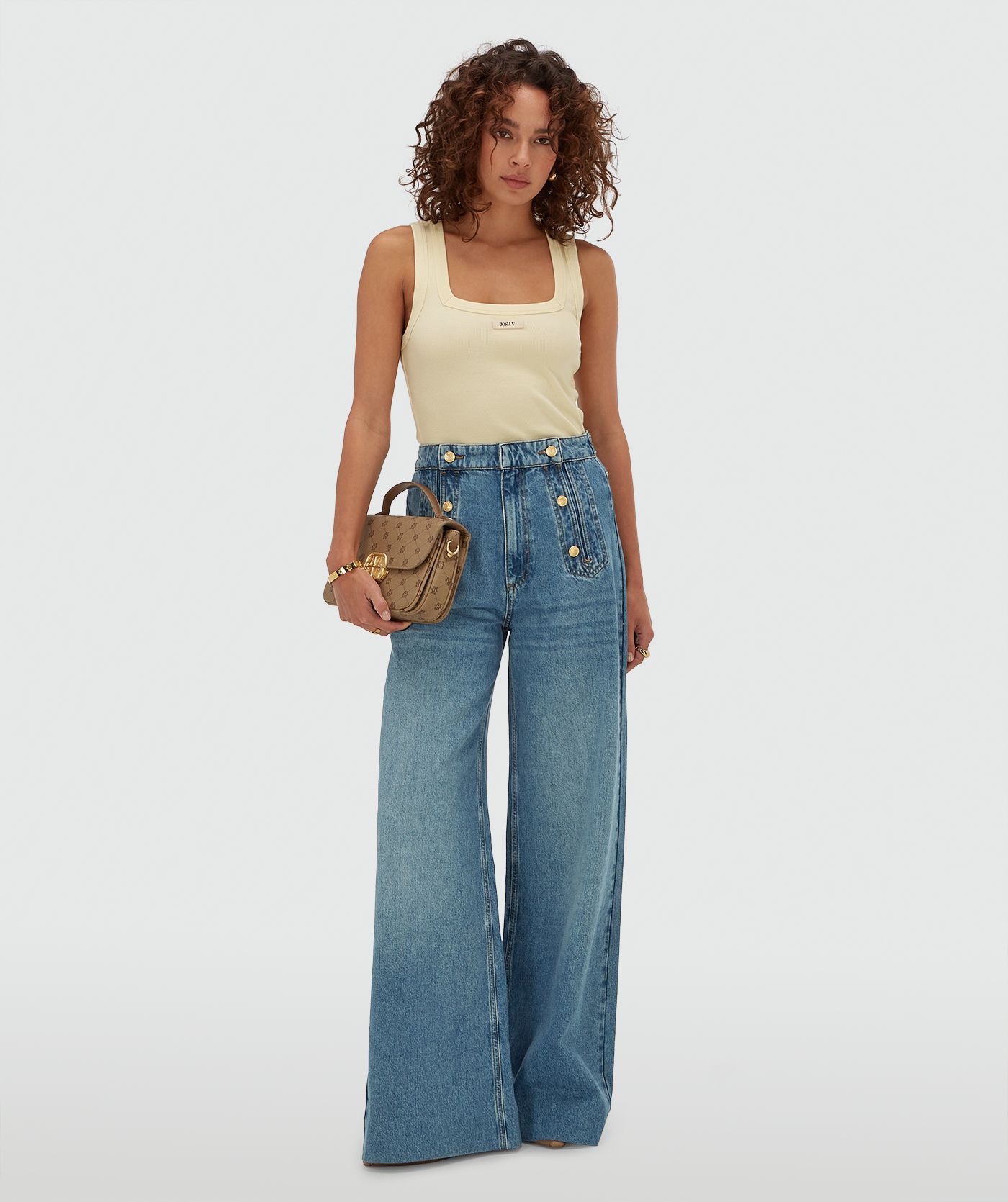  Model draagt een slim fit top met logo in de kleur Butter Yellow