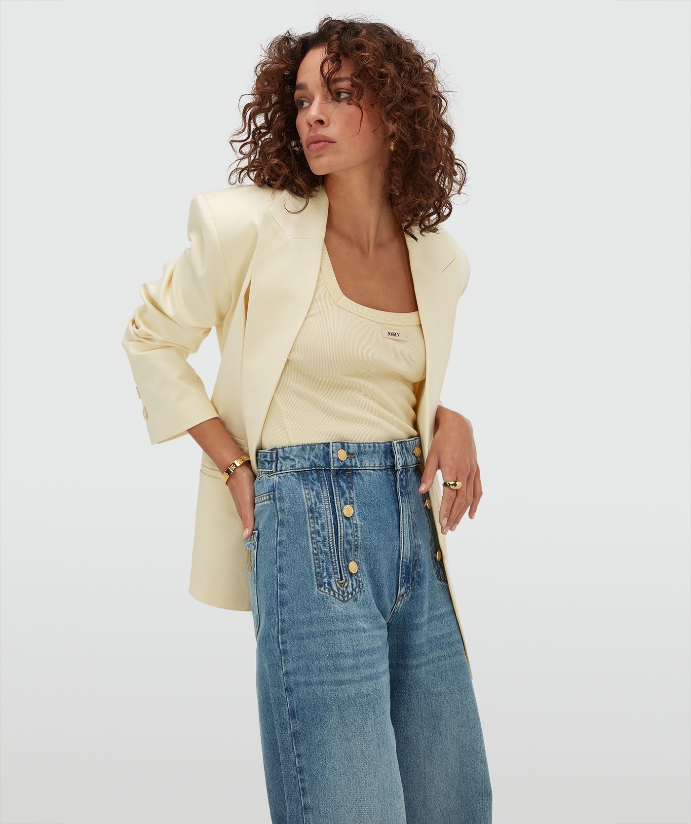 Model draagt een slim fit top met logo in de kleur Butter Yellow