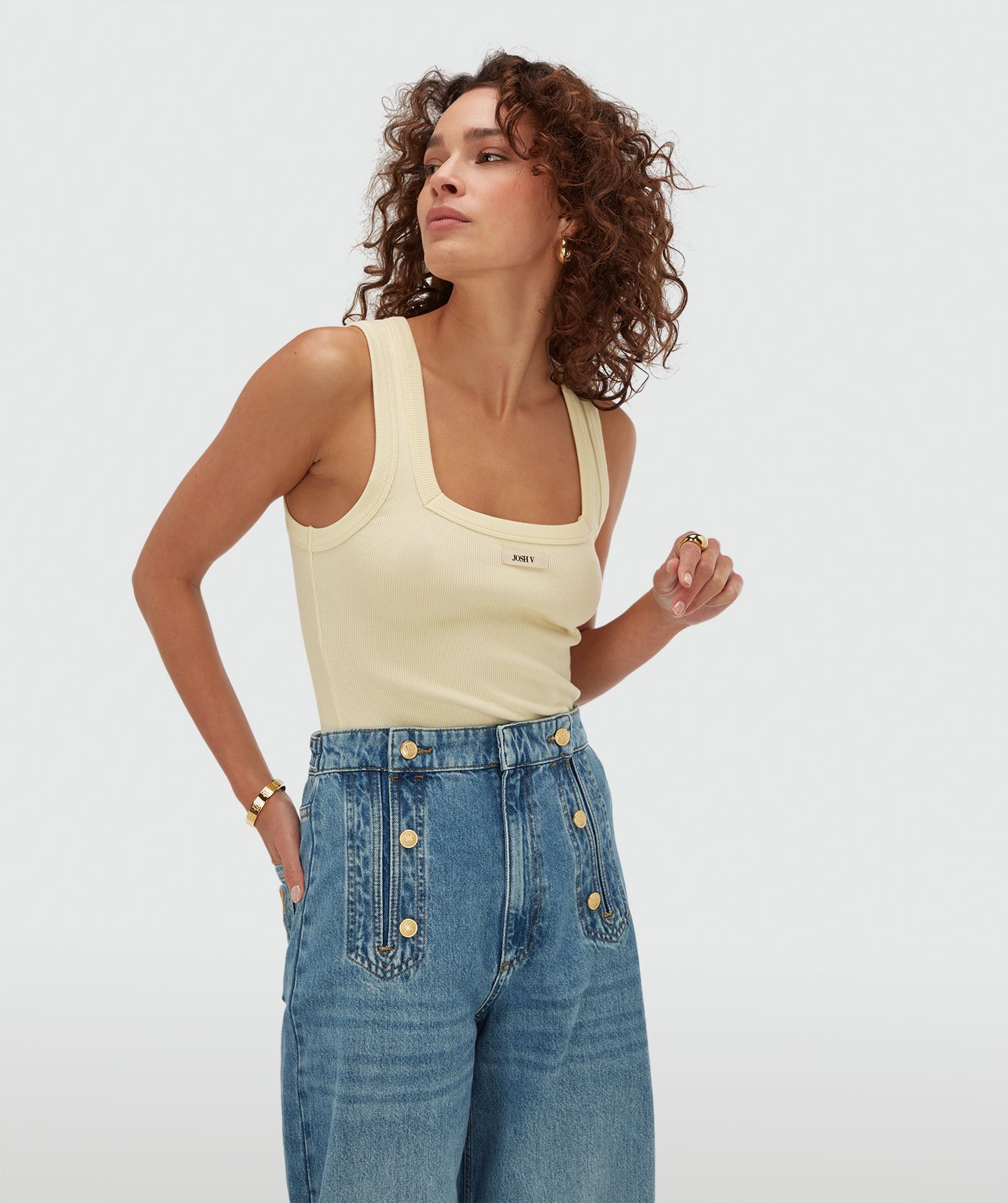  Model draagt een slim fit top met logo in de kleur Butter Yellow