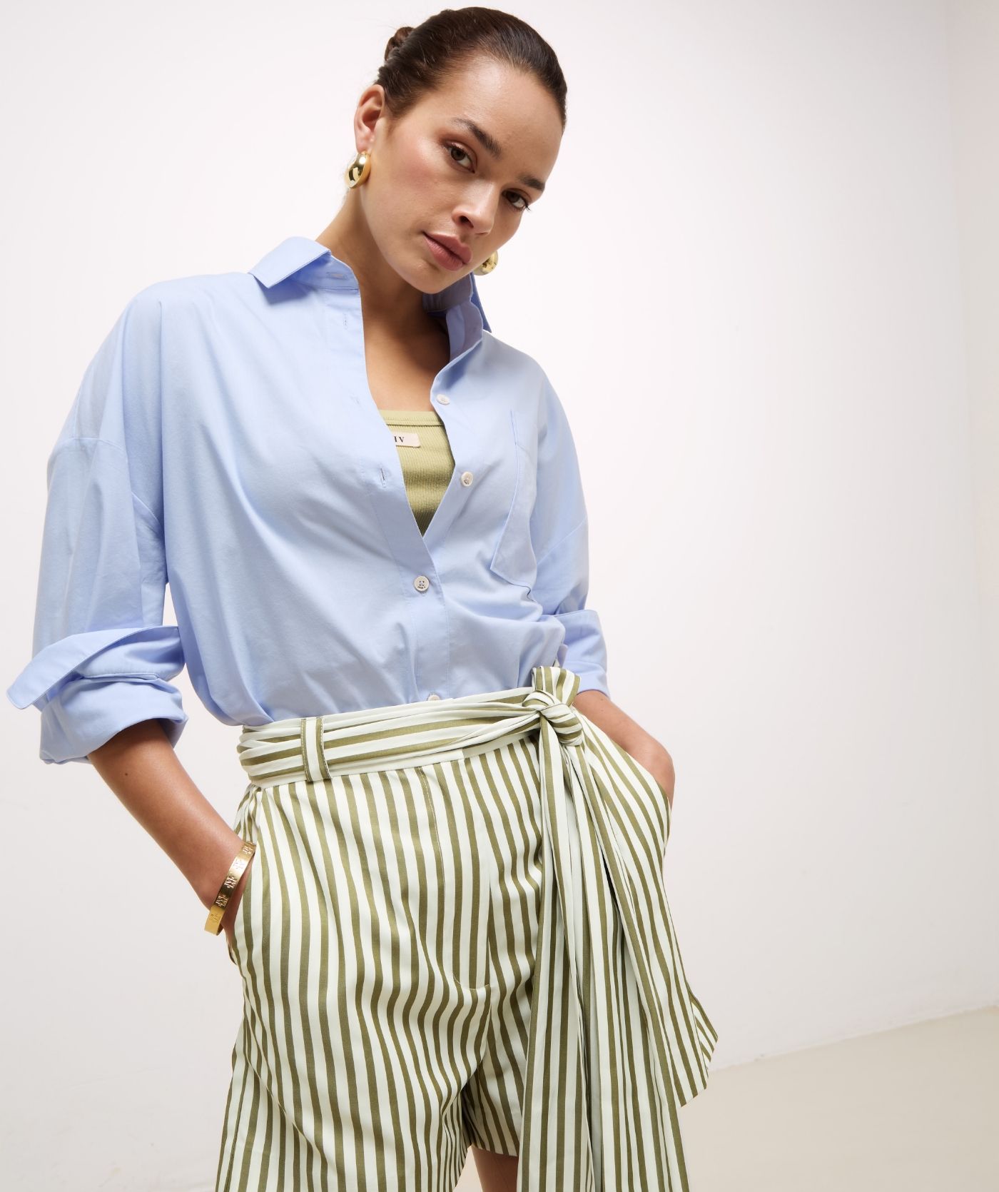 Model draagt een slim fit top met logo in de kleur Dark Pistachio