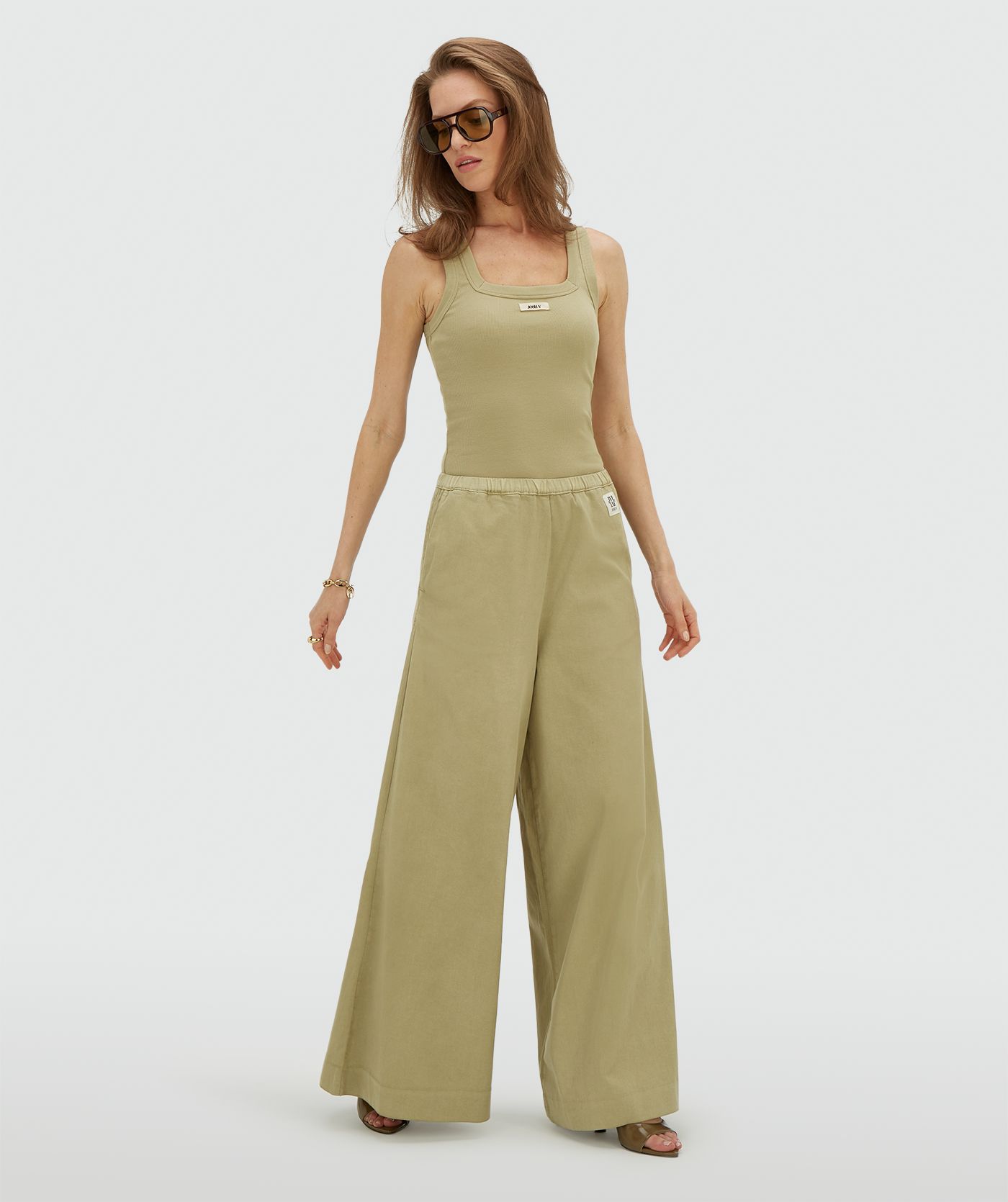 Model draagt een slim fit top met logo in de kleur Dark Pistachio