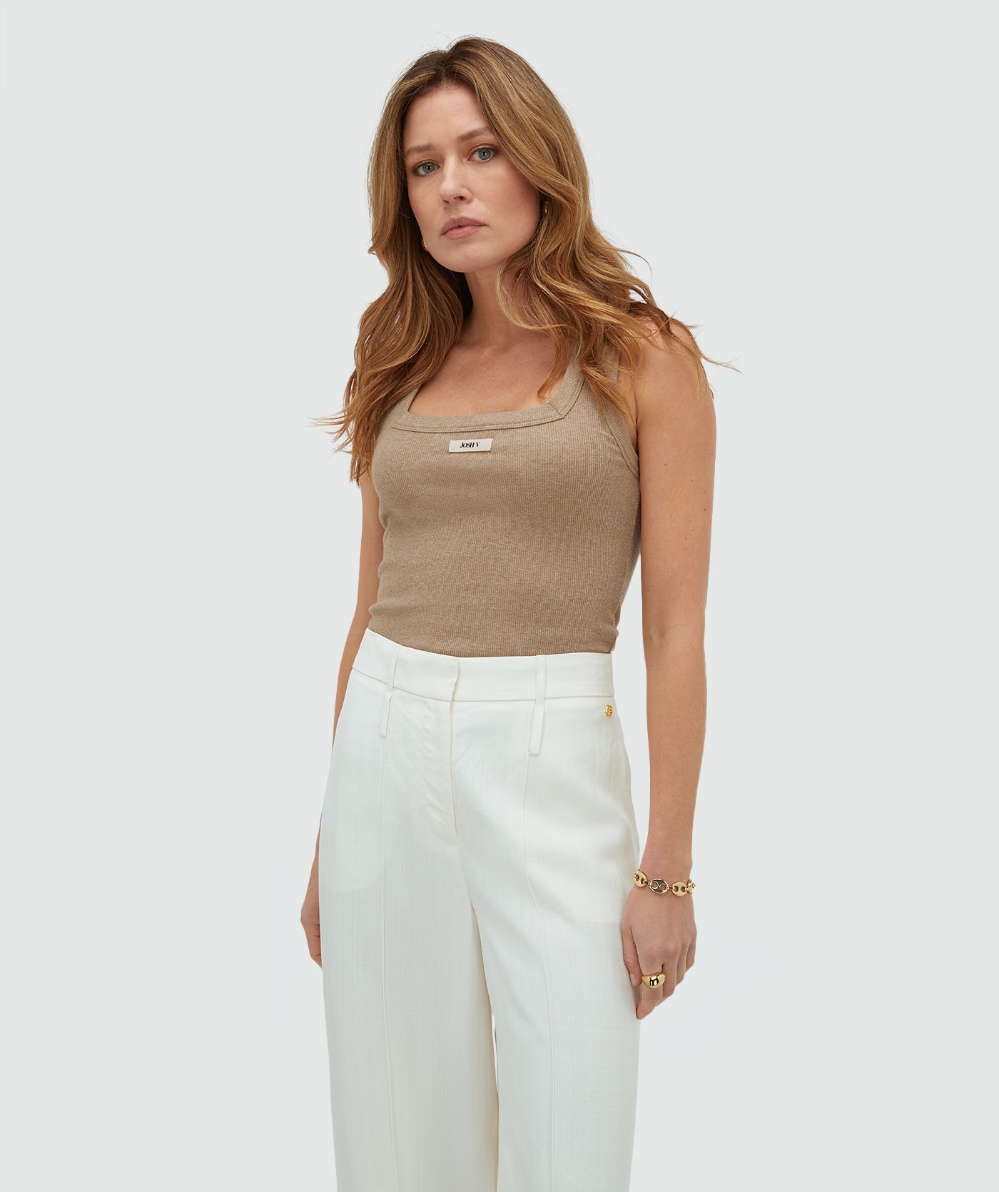 Model draagt een slim fitted top met logo, in de kleur Khaki Melange