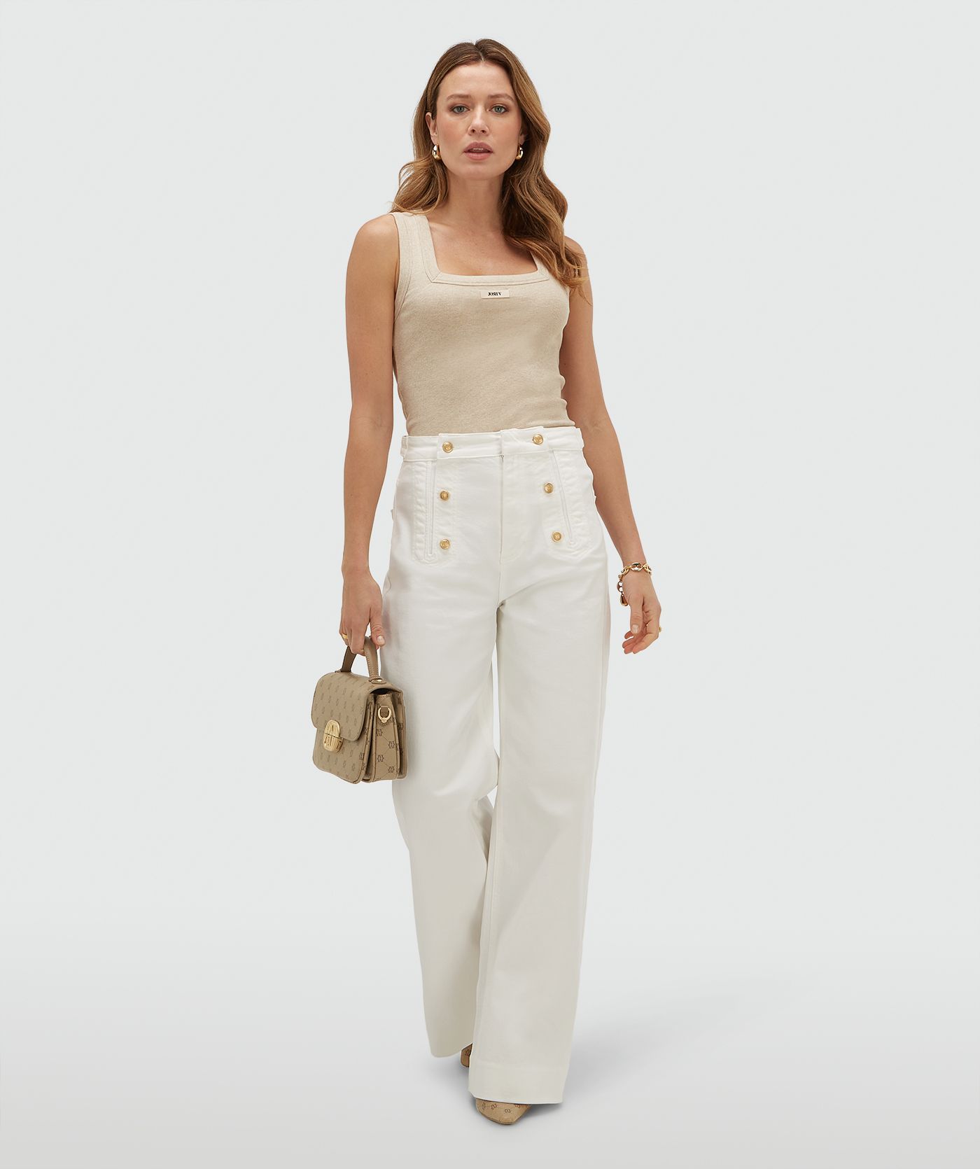 Model draagt een slim fitted top met logo, in de kleur Oat Melange