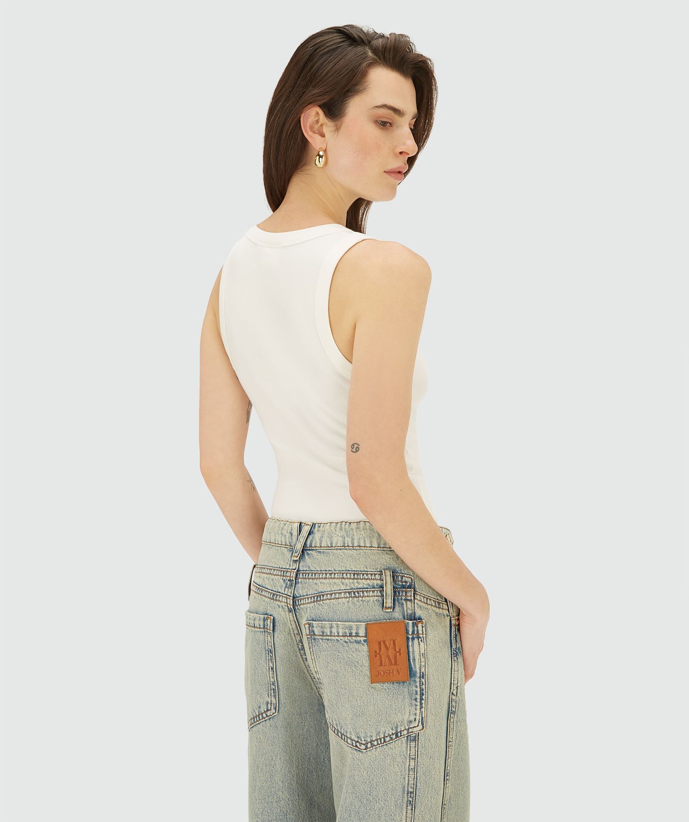 Achteraanzicht van model in een Off white T-shirt zonder mouwen met JOSH V embleem op de borst