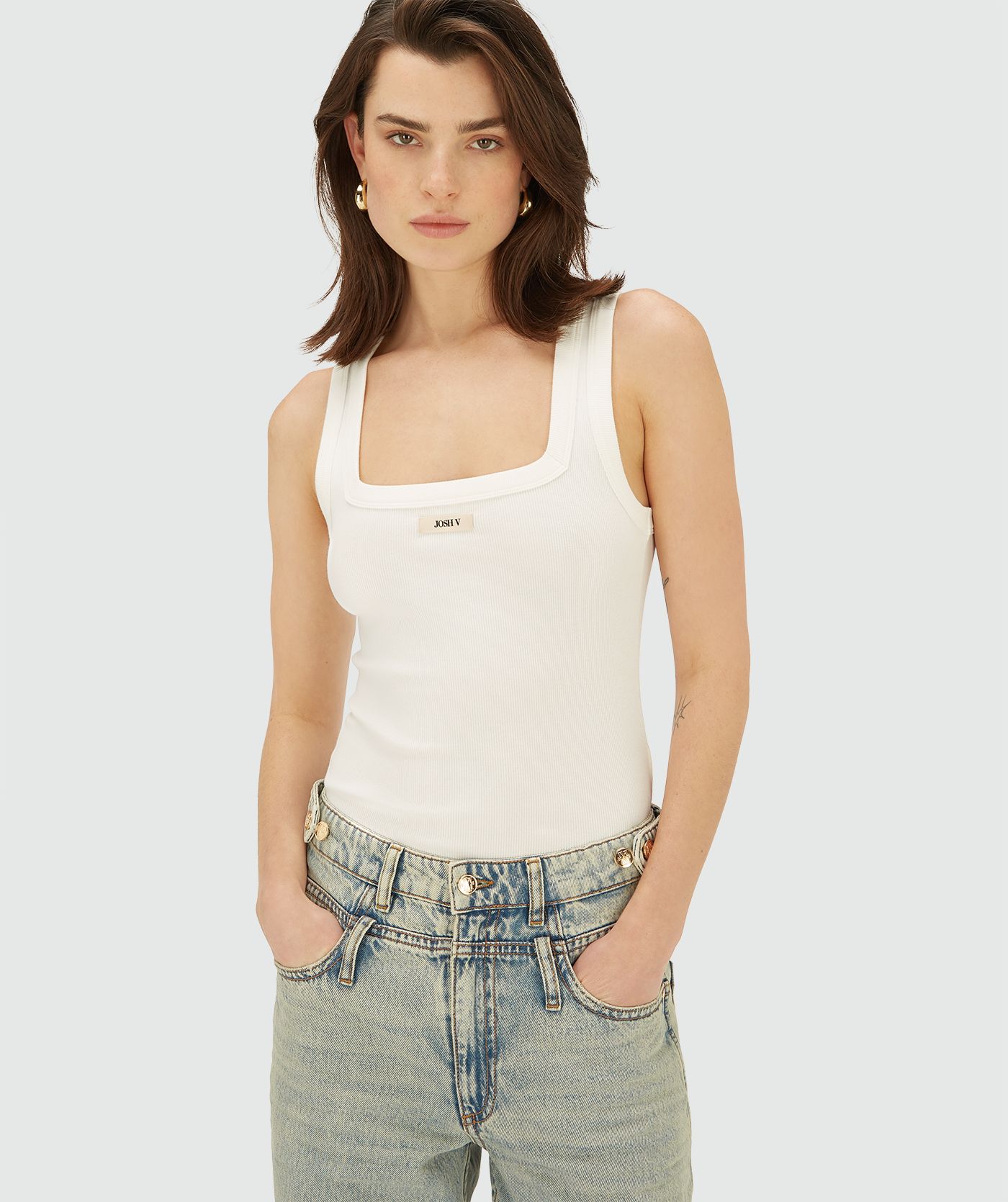 Model draagt een Off white T-shirt zonder mouwen met JOSH V embleem op de borst