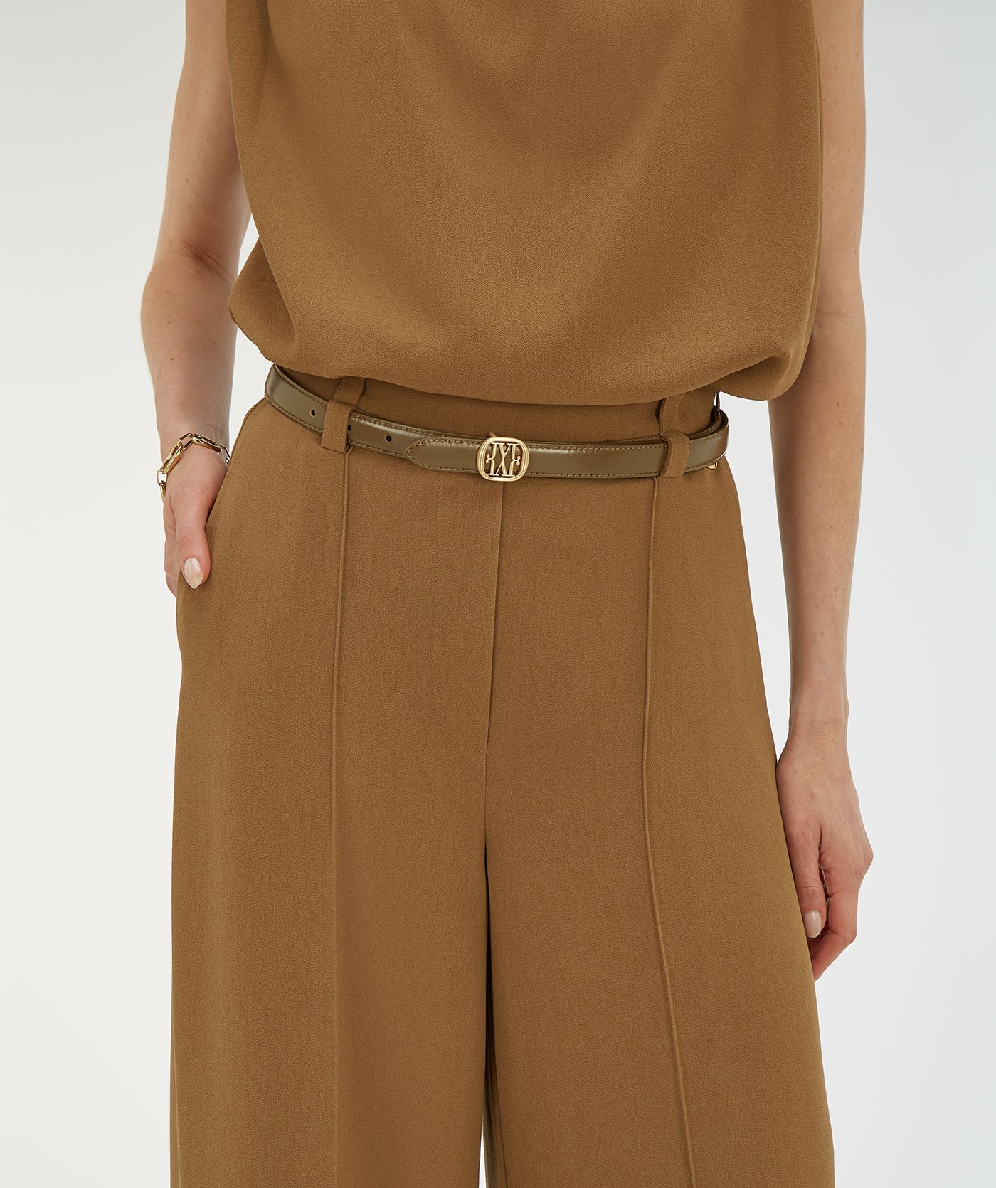 Model draagt een riem met logo in de kleur Creme White Khaki