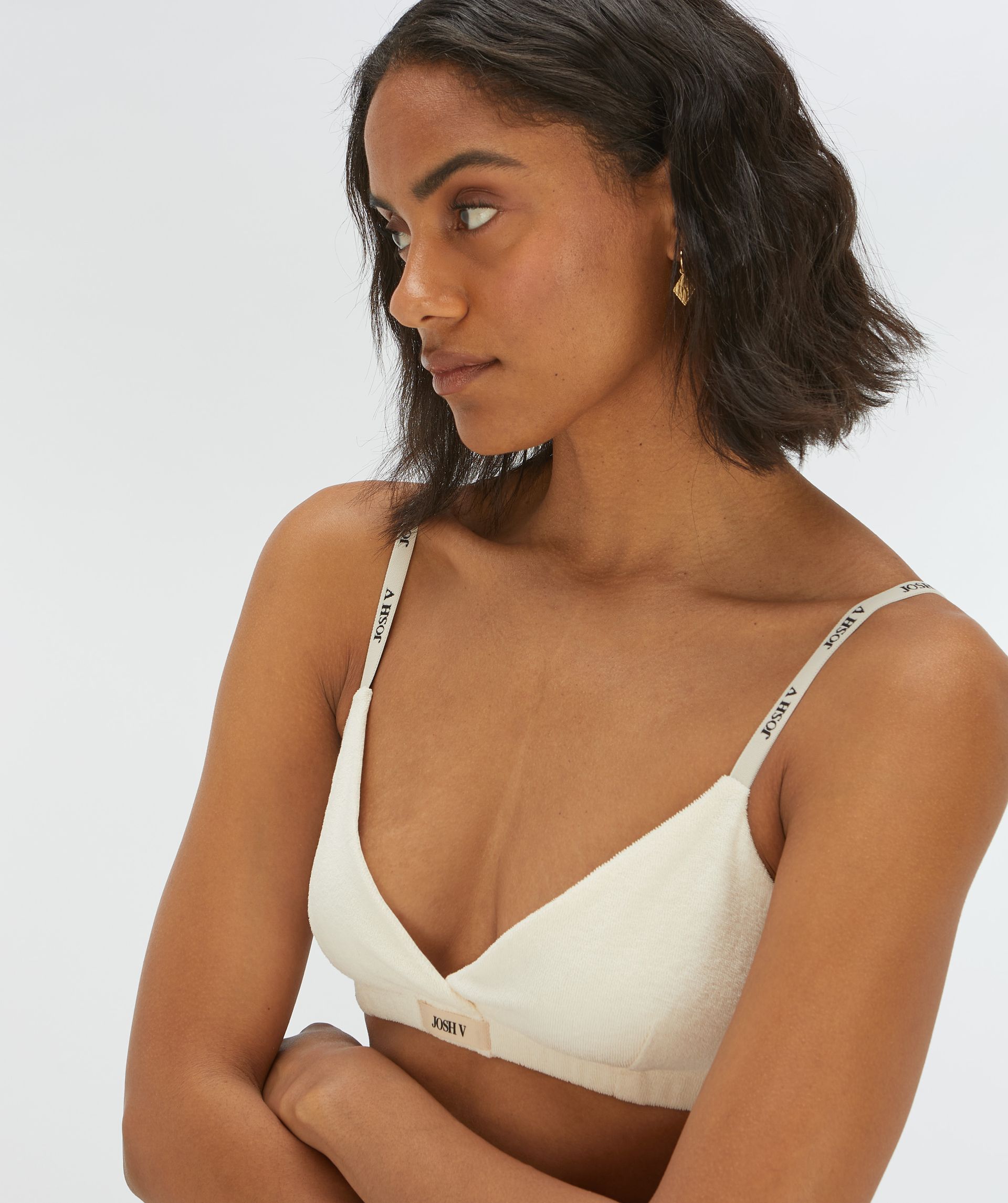 Model draagt een bralette in de kleur gebroken wit - Josh V.