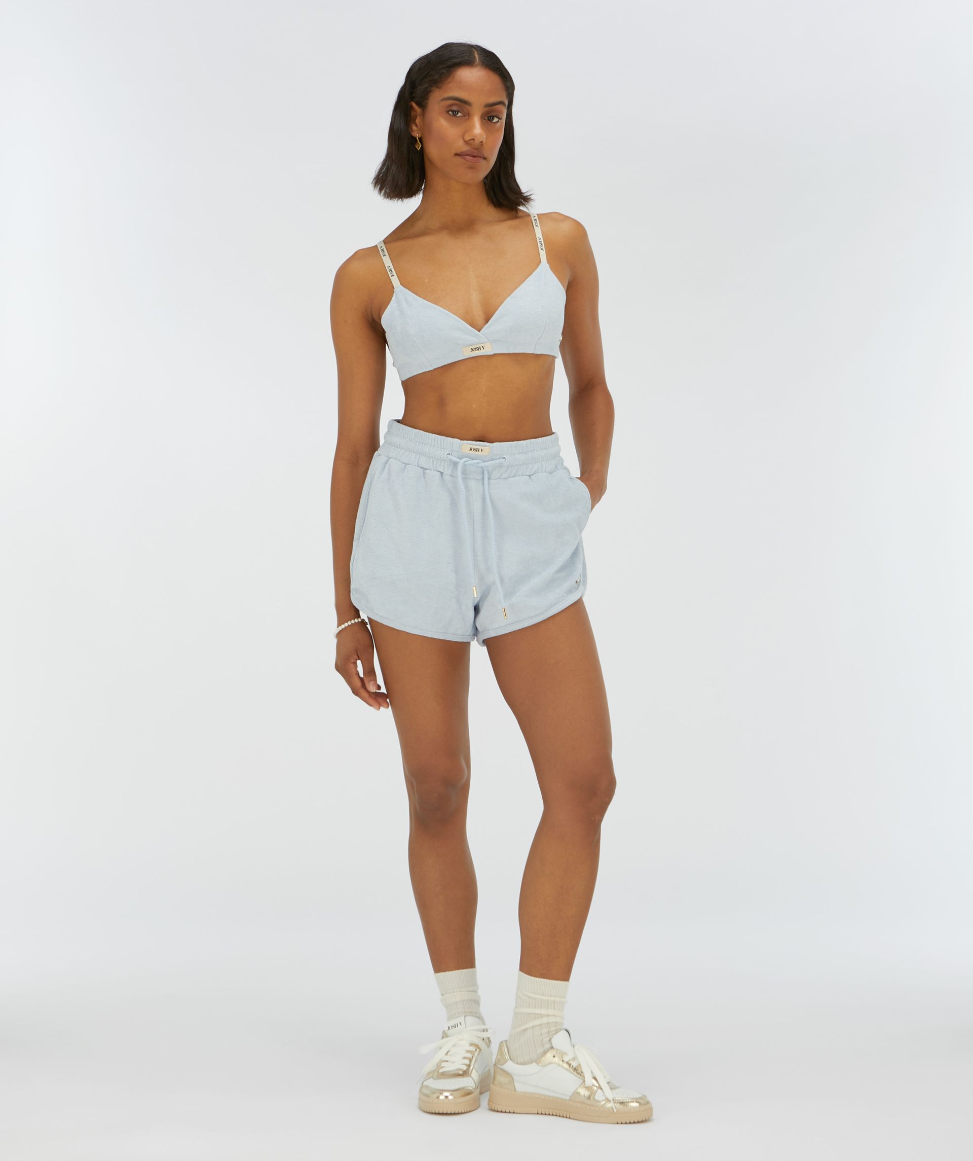 Model draagt een bralette in de kleur lichtblauw met bandjes voorzien van JOSH V-logo’s - Josh V.