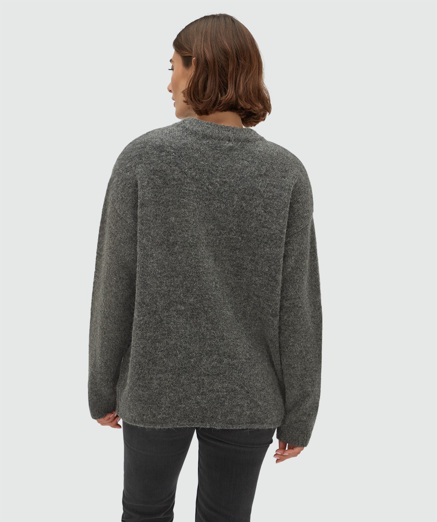 Achteraanzicht van een model in een oversized trui met wol