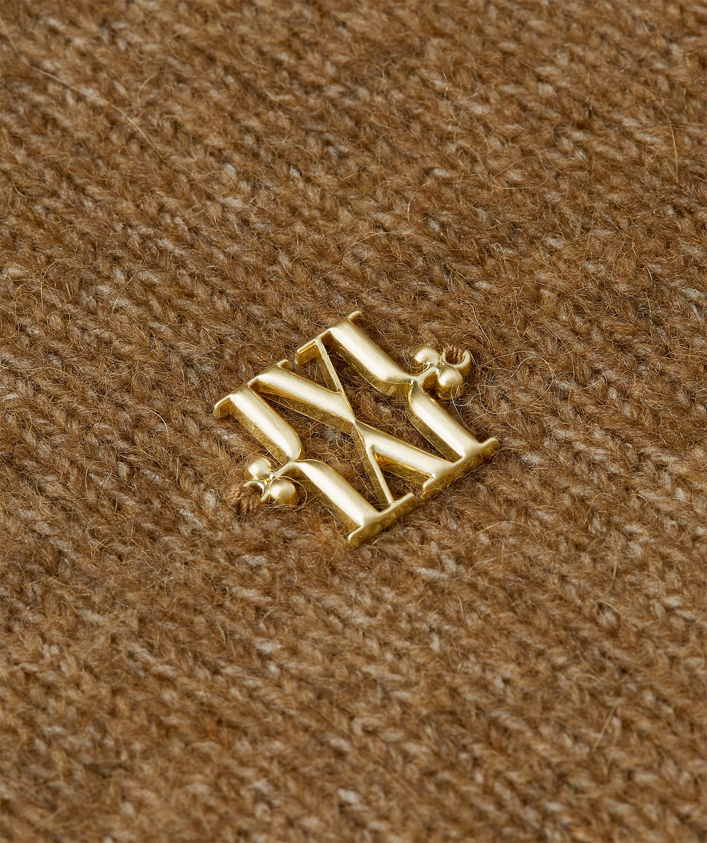 Close-up van gouden JOSH V-logo op de borst.