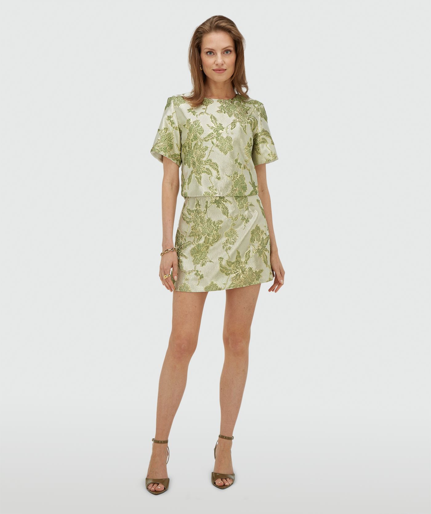 Model draagt een high waisted rok met metallic details in de kleur Dark Pistachio