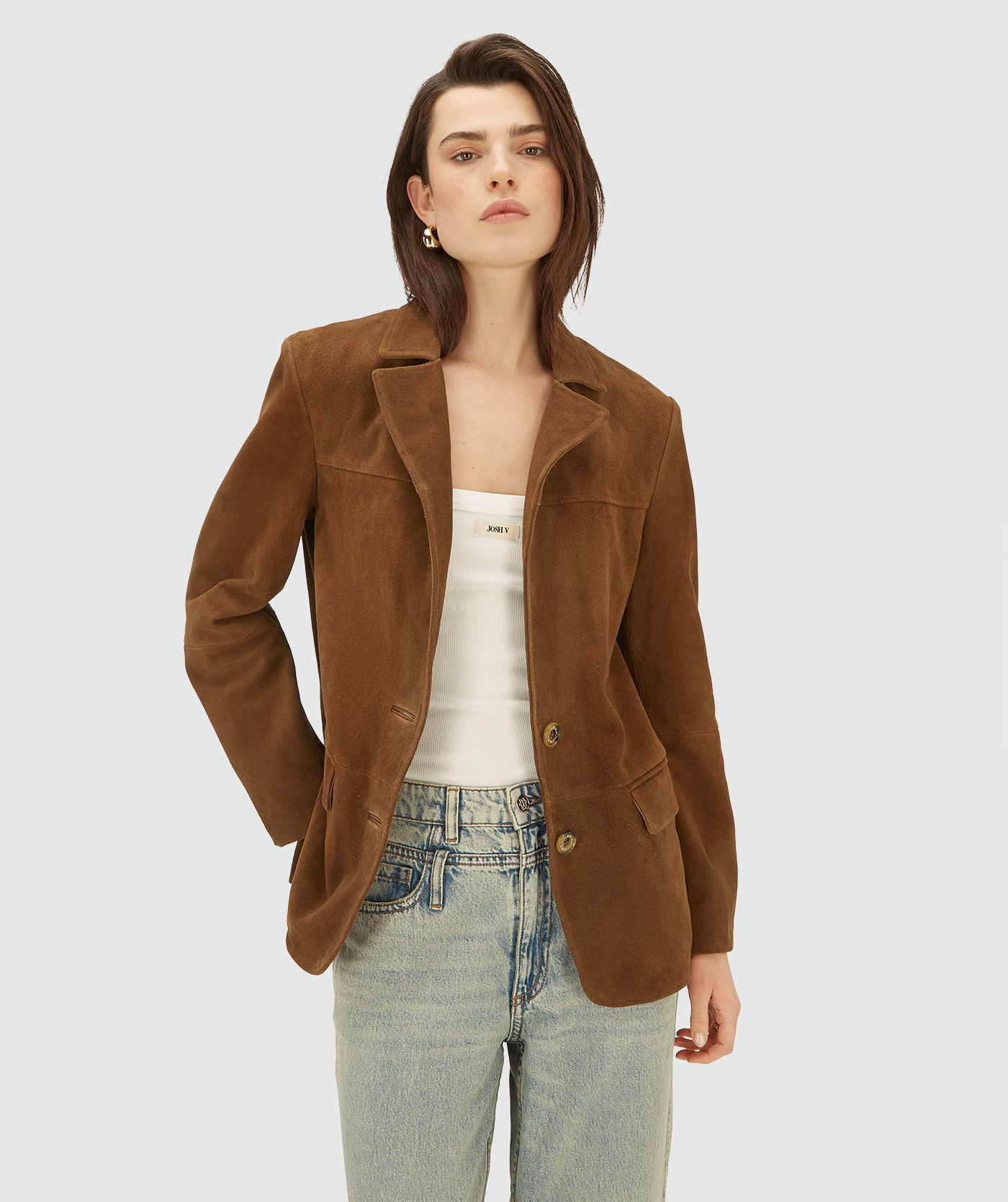 Model in een bruine suède blazer met knoopsluiting