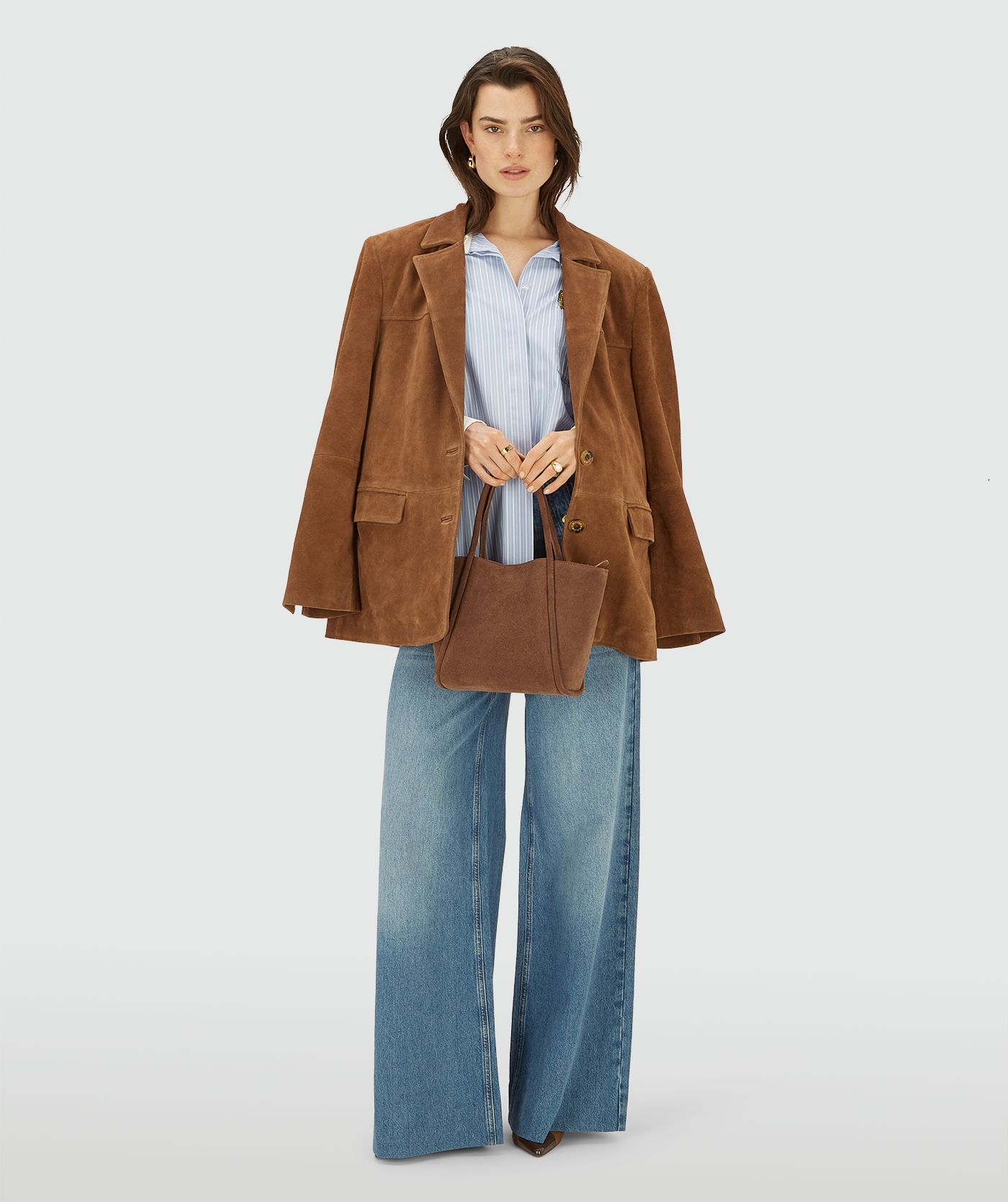 Model in een bruine suède blazer met knoopsluiting