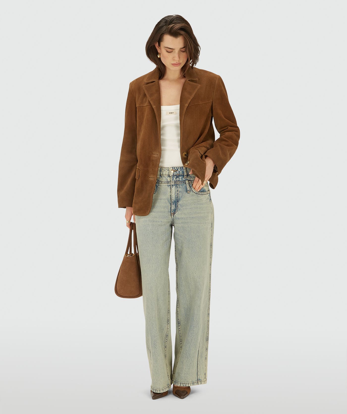 Model in een bruine suède blazer met knoopsluiting.