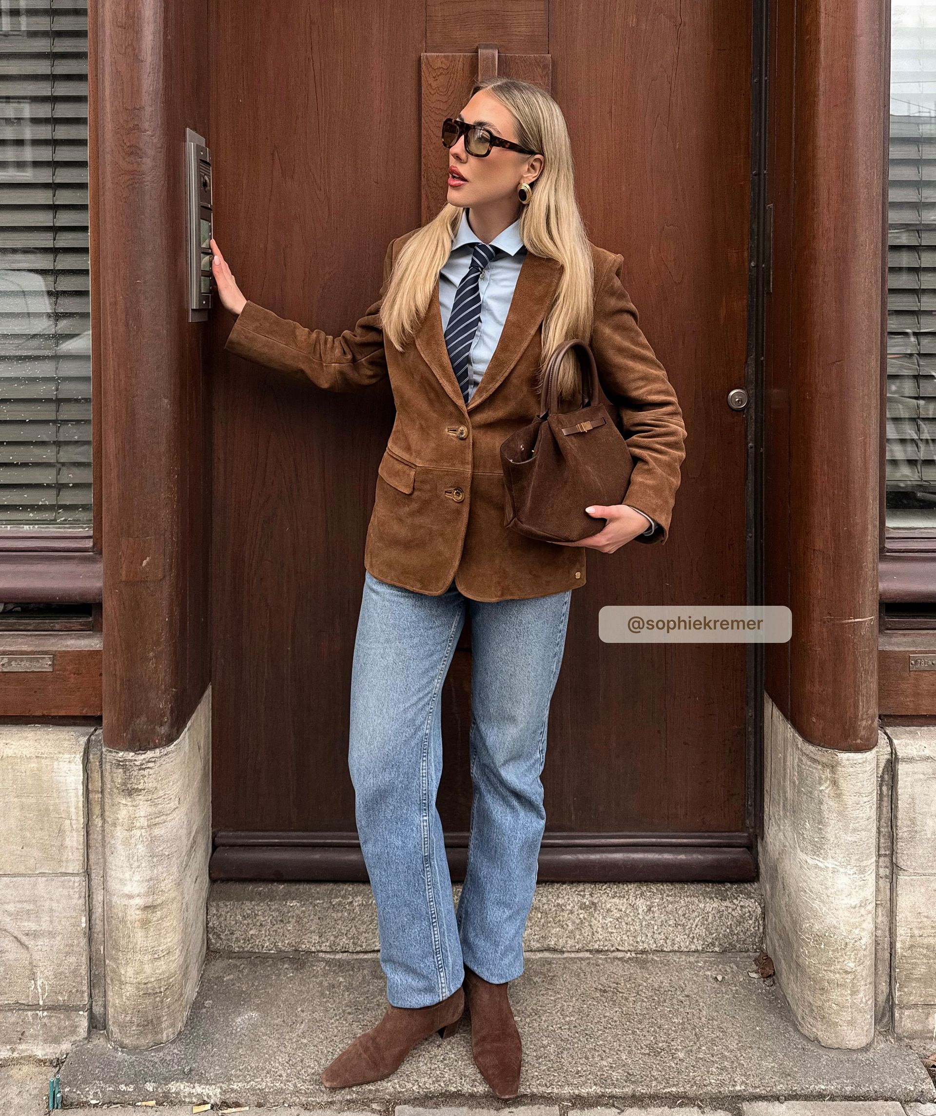 Model draagt een bruine suède blazer met knoopsluiting