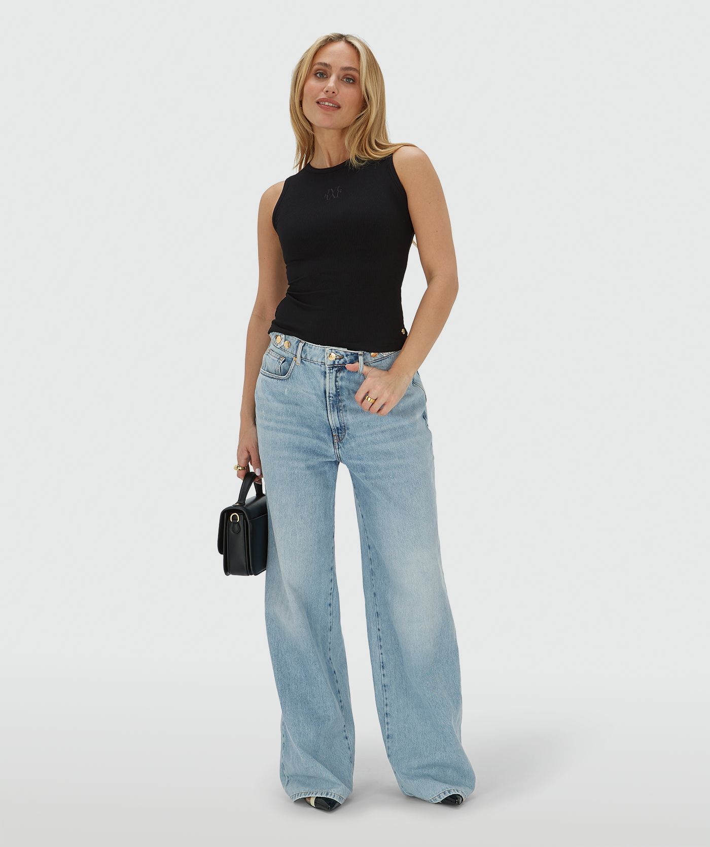 Het model draagt een super fitted top in zwart, voorzien van een JOSH V-logo borduursel op de voorzijde