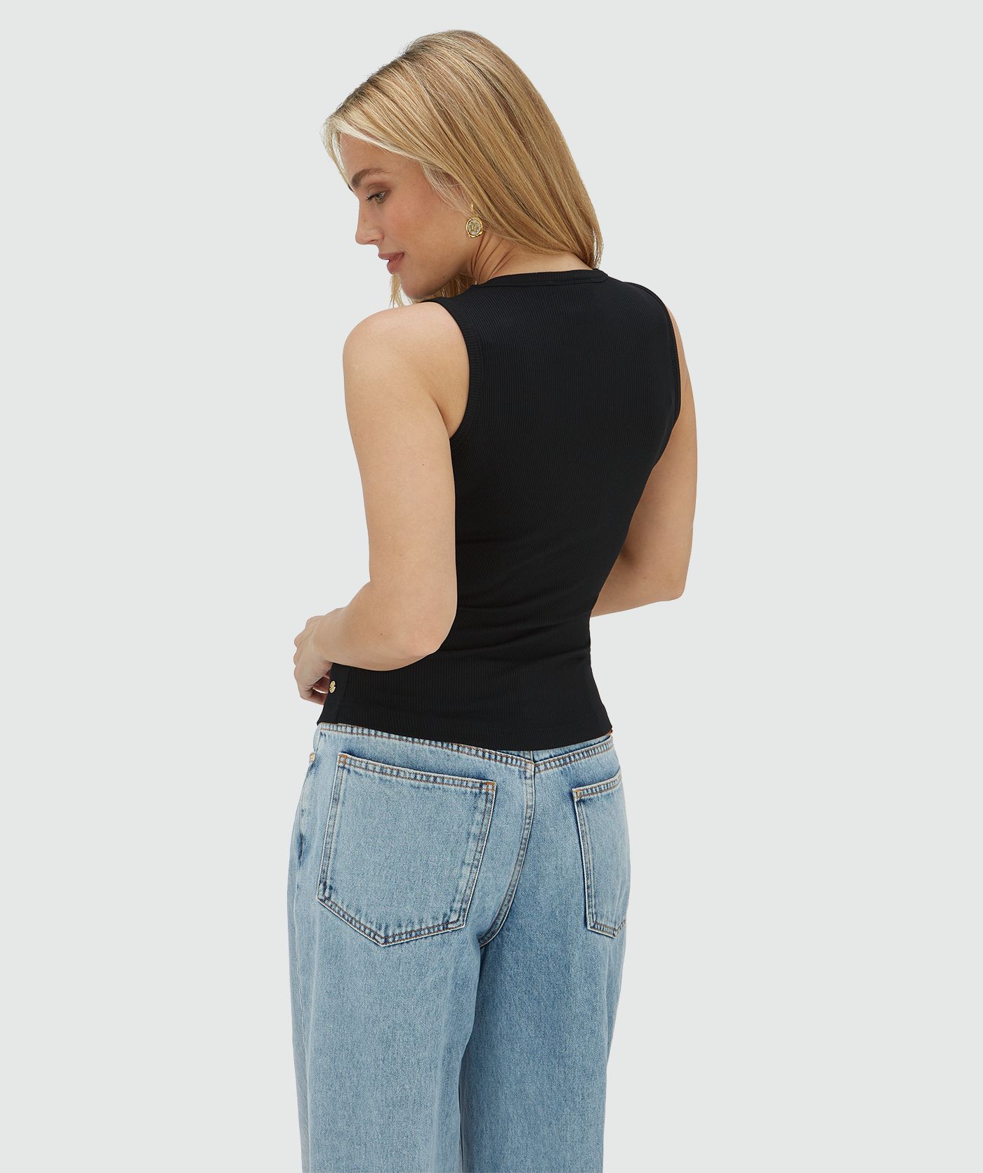 Achterzijde van een model in een super fitted top in het zwart