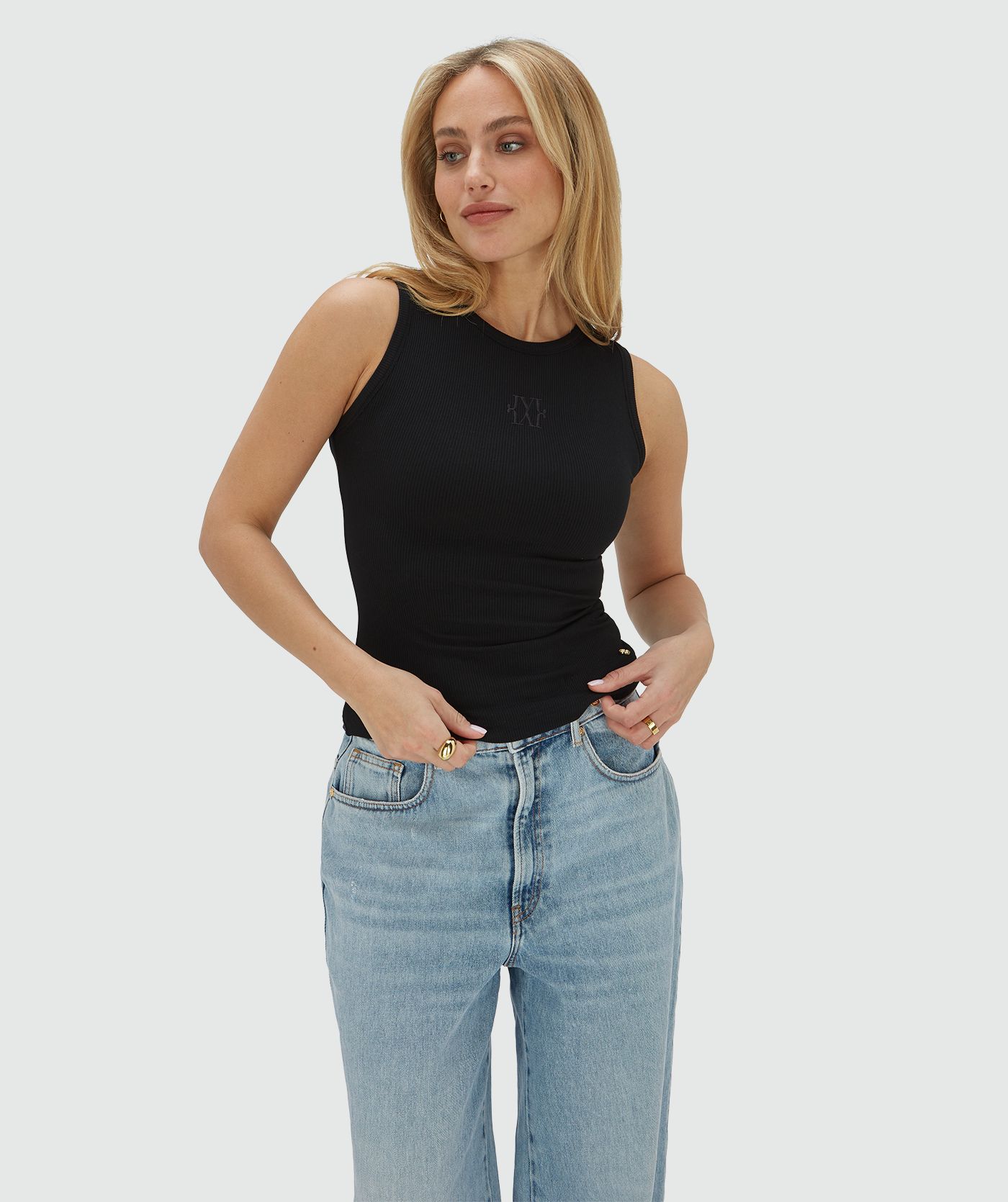 Het model draagt een super fitted top in zwart, voorzien van een JOSH V-logo borduursel op de voorzijde