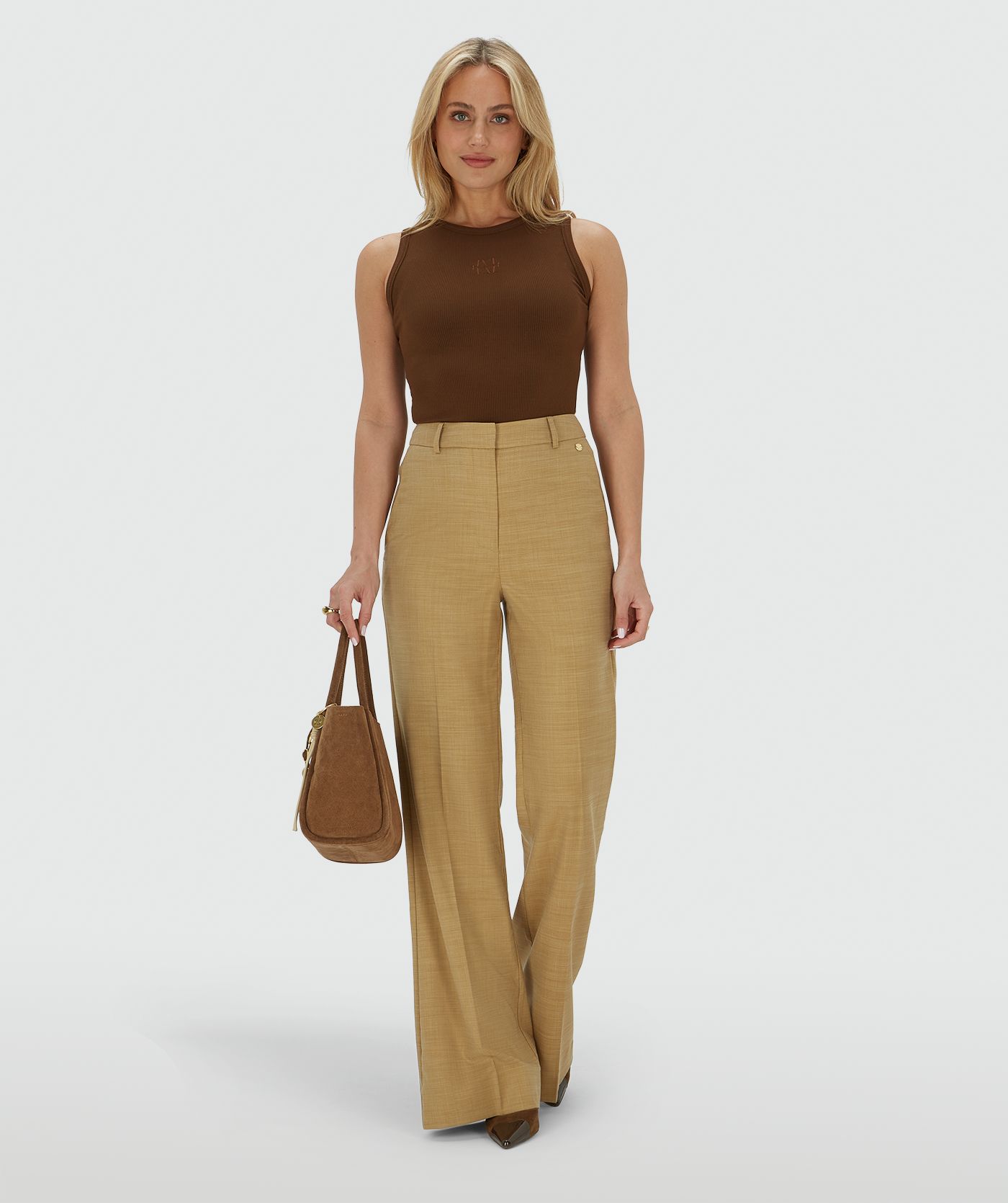 Het model draagt een super fitted top in het bruin, voorzien van een JOSH V-logo borduursel op de voorzijde