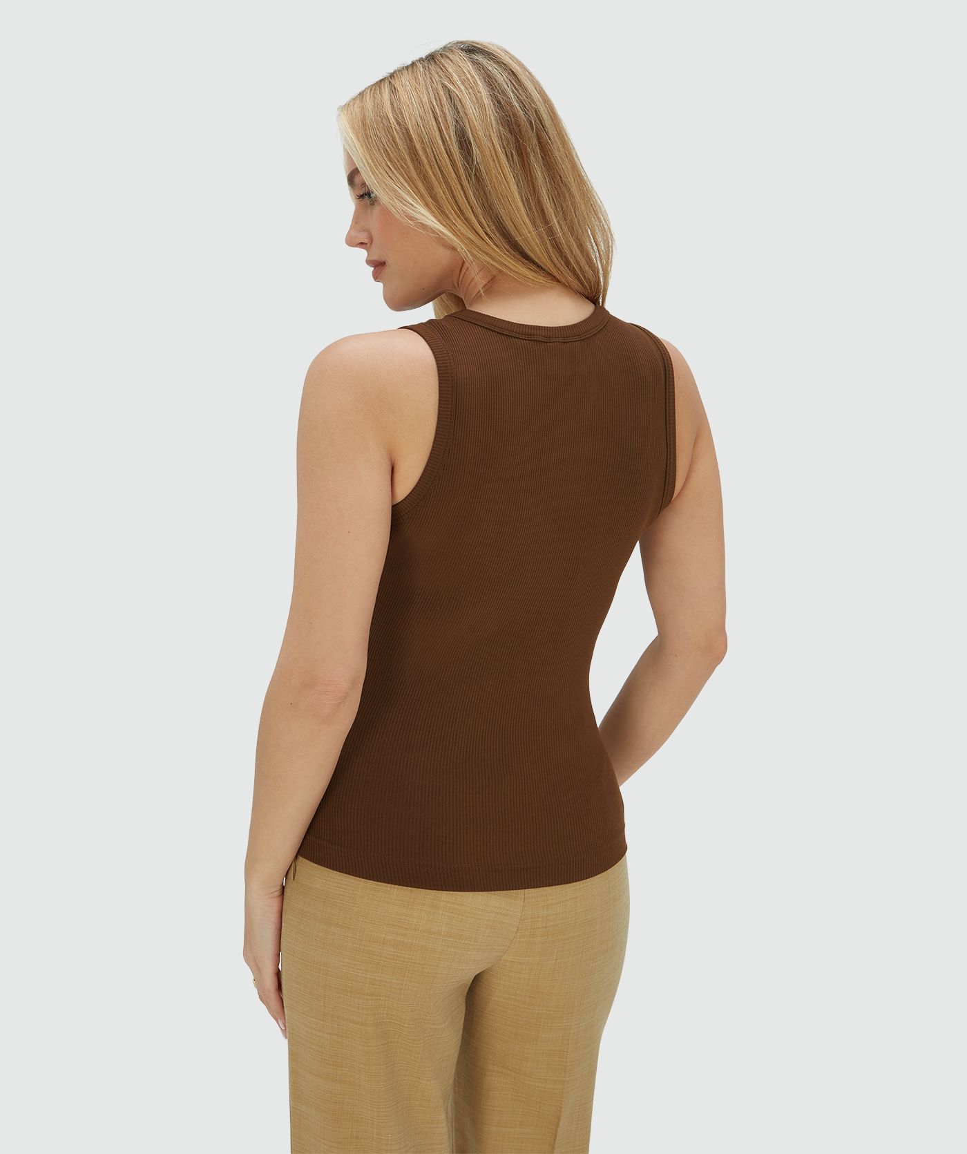Achterzijde van een model in een super fitted top in het bruin