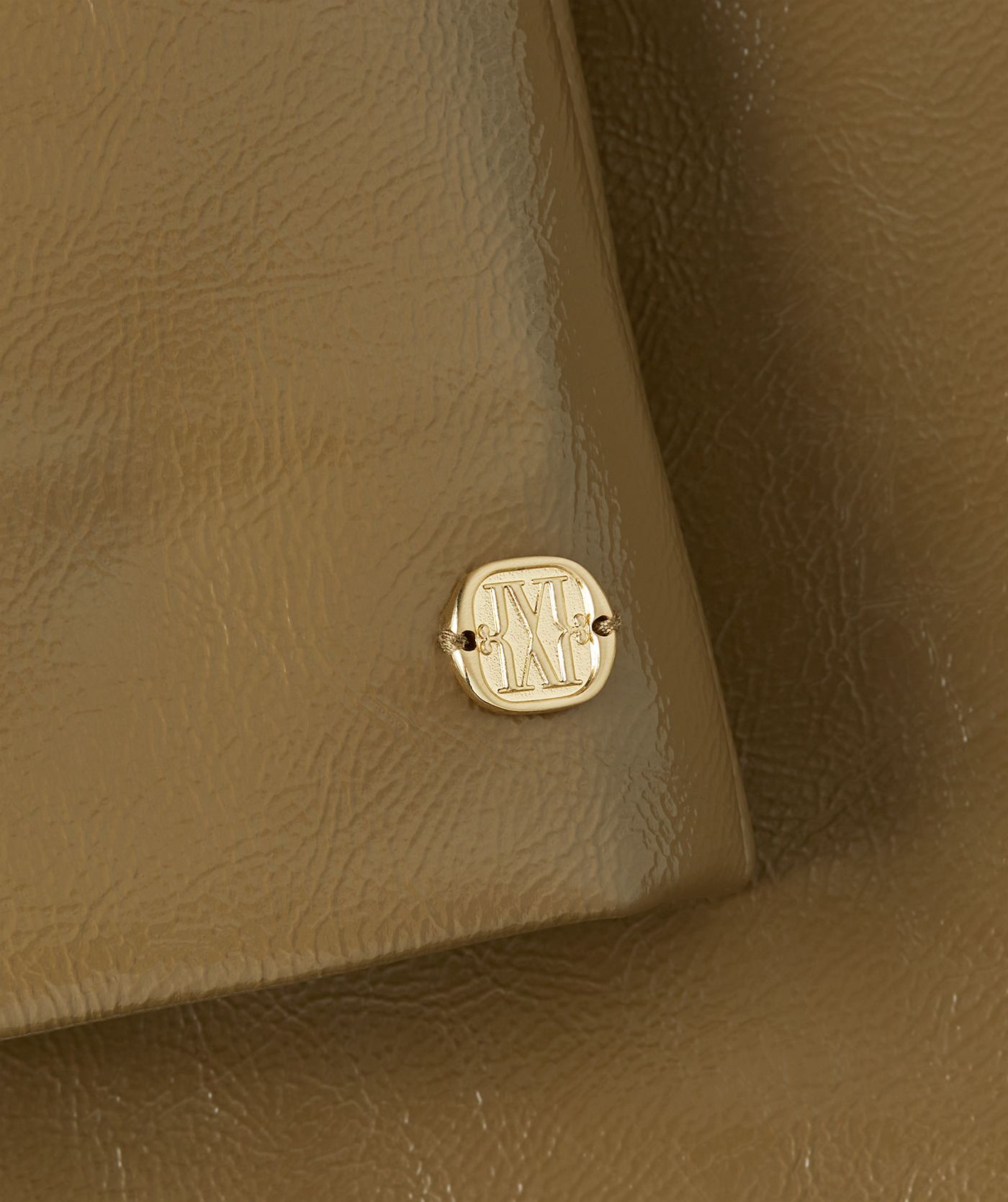 Close-up goudkleurige JOSH V monogram embleem