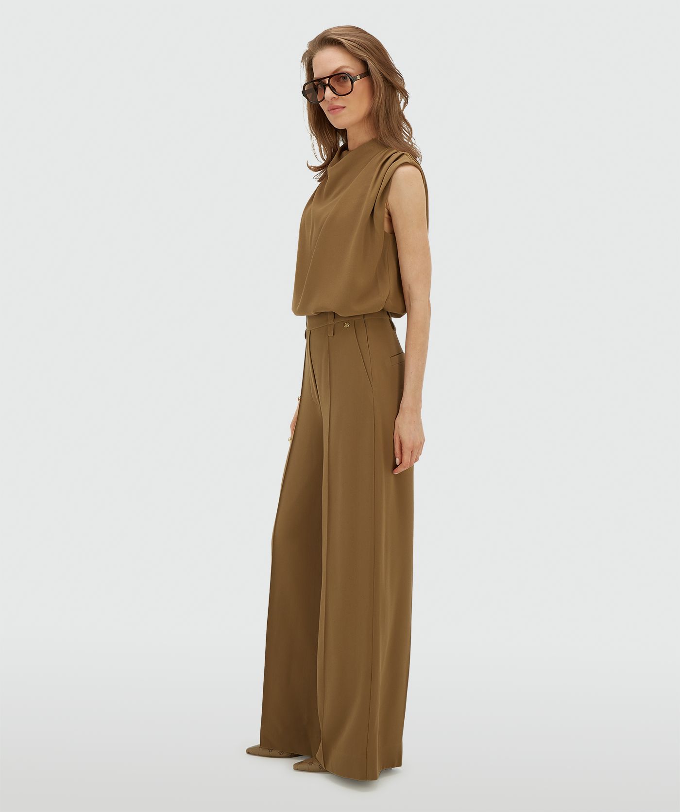 Model draagt een high waisted wide leg pantalon in de kleur Khaki