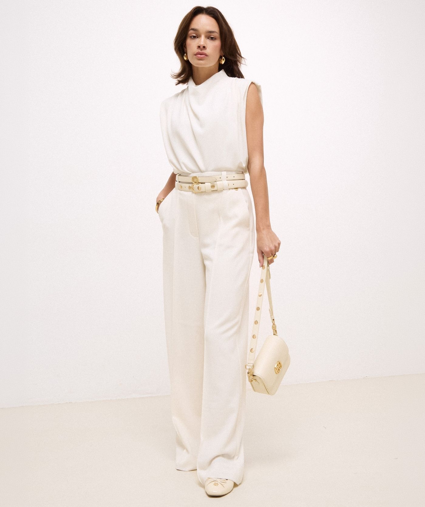 Model draagt een high waisted wide leg pantalon in de kleur Off White
