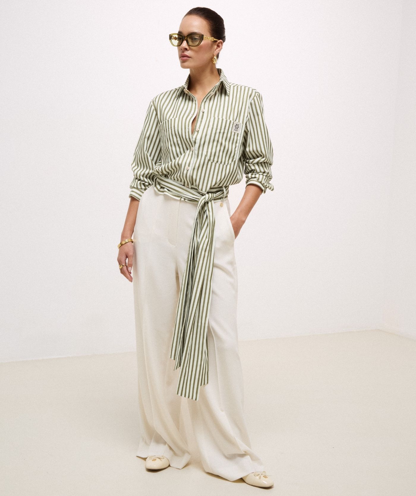 Model draagt een high waisted wide leg pantalon in de kleur Off White