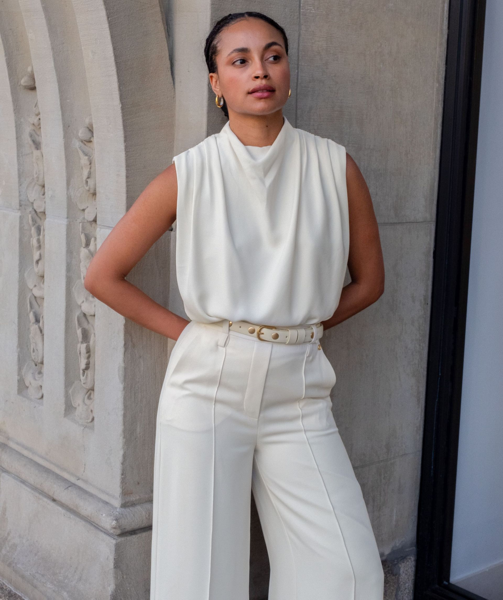 Model draagt een high waisted wide leg pantalon in de kleur Off White