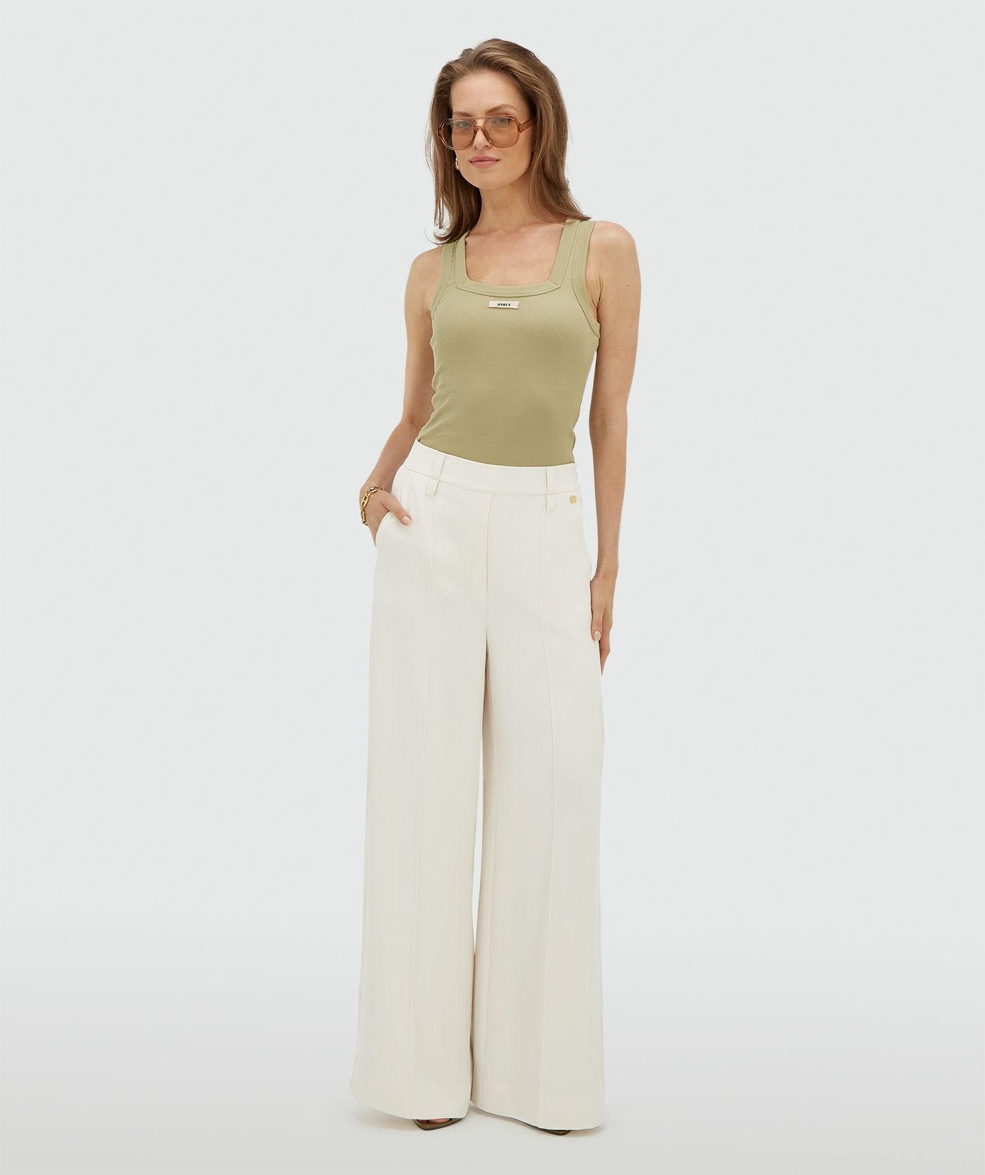 Model draagt een high waisted wide leg pantalon in de kleur Off White