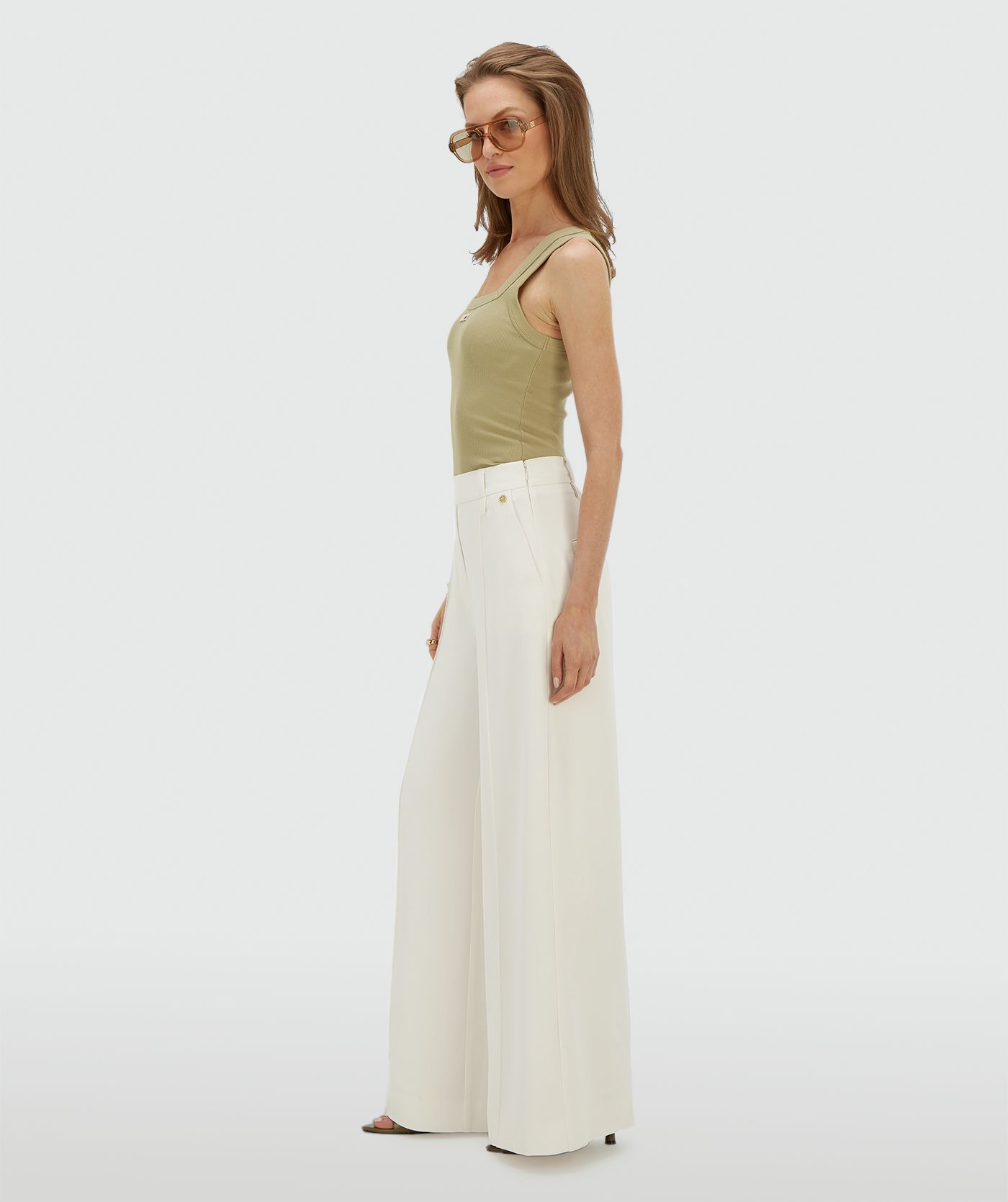 Zijaanzicht van een model in een high waisted wide leg pantalon in de kleur Off White