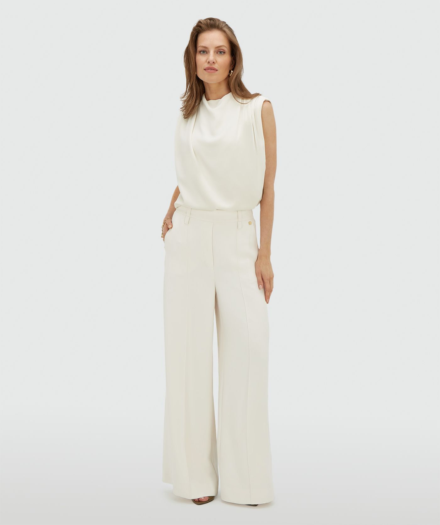 Model draagt een high waisted wide leg pantalon in de kleur Off White