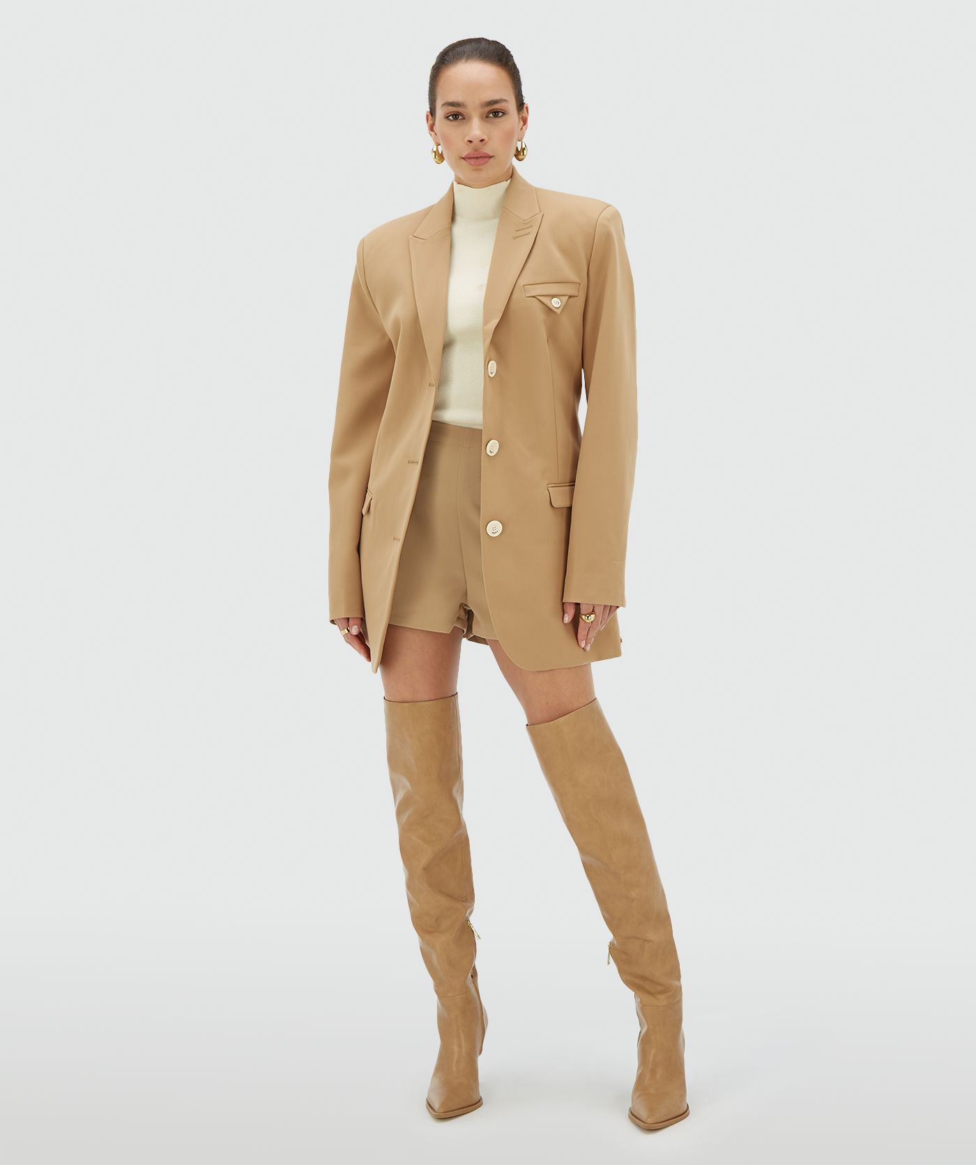 Model draagt een Light Brown oversized blazerjurk met schoudervullingen en een non-functionele borstzak - Josh V