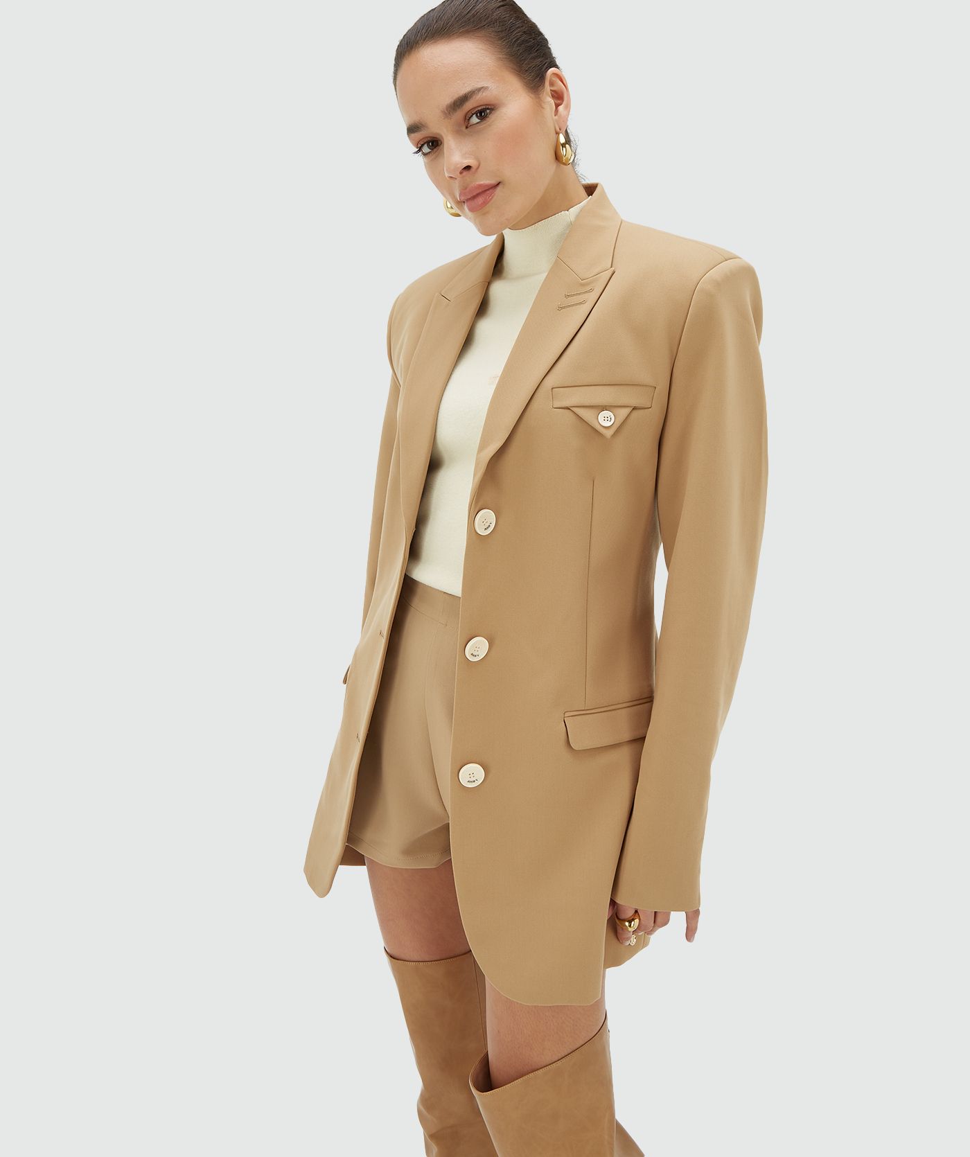 Model draagt een Light Brown oversized blazerjurk met schoudervullingen en een non-functionele borstzak - Josh V