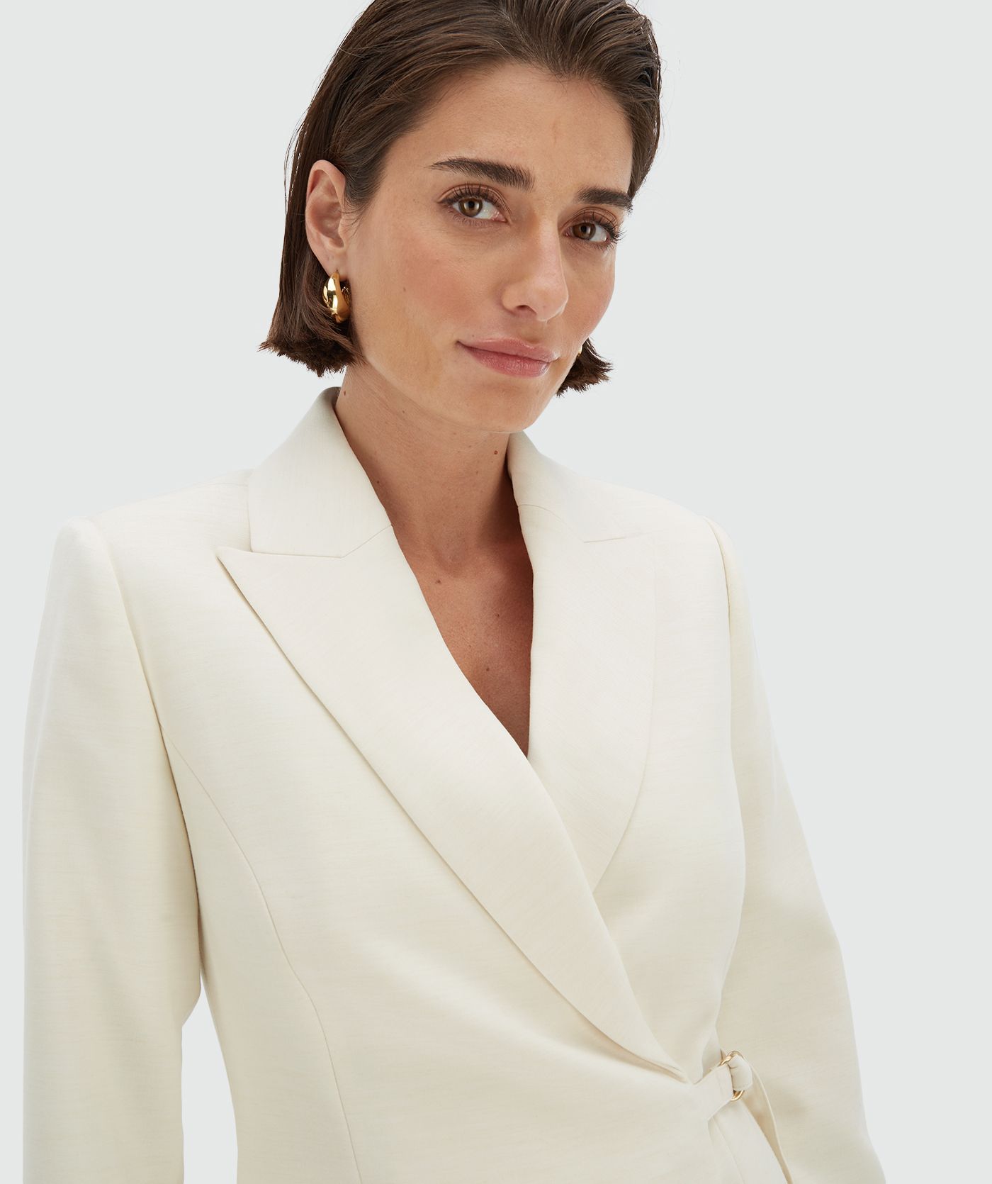 Model draagt een Creme White relaxed fit blazerjurk met verstelbare strap - Josh V