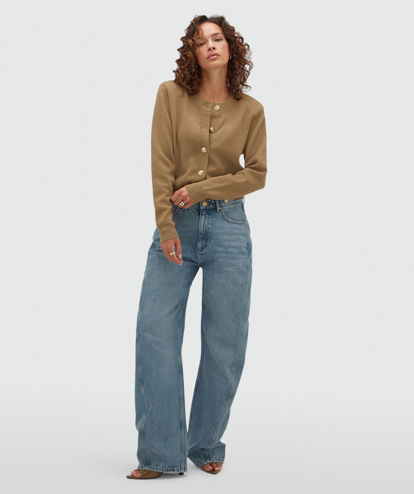 Model draagt een vest met gouden knopen in de kleur Khaki.
