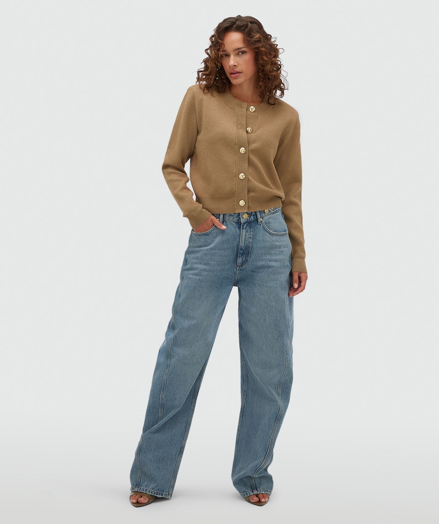 Model draagt een vest met gouden knopen in de kleur Khaki.