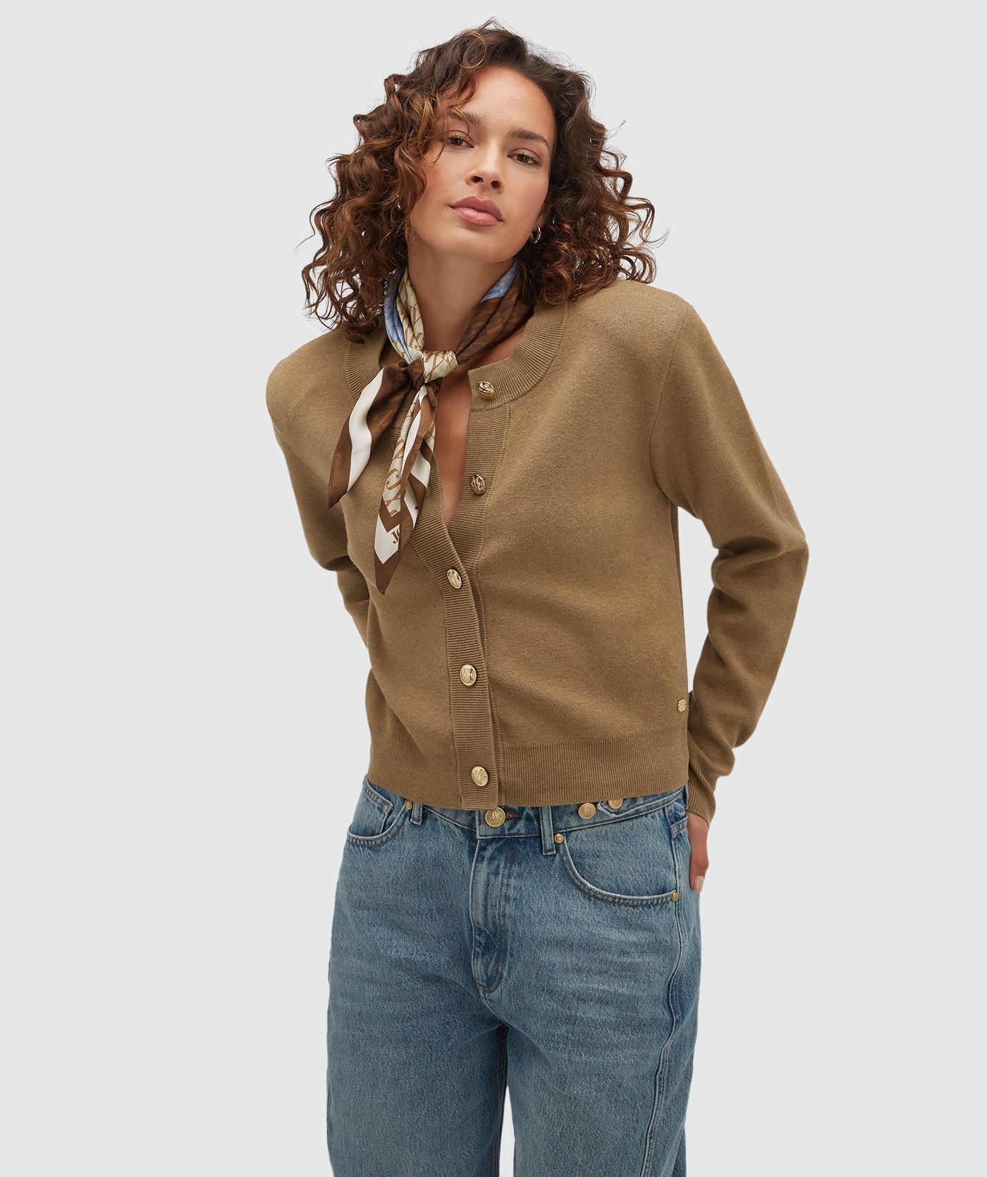 Model draagt een vest met gouden knopen in de kleur Khaki.