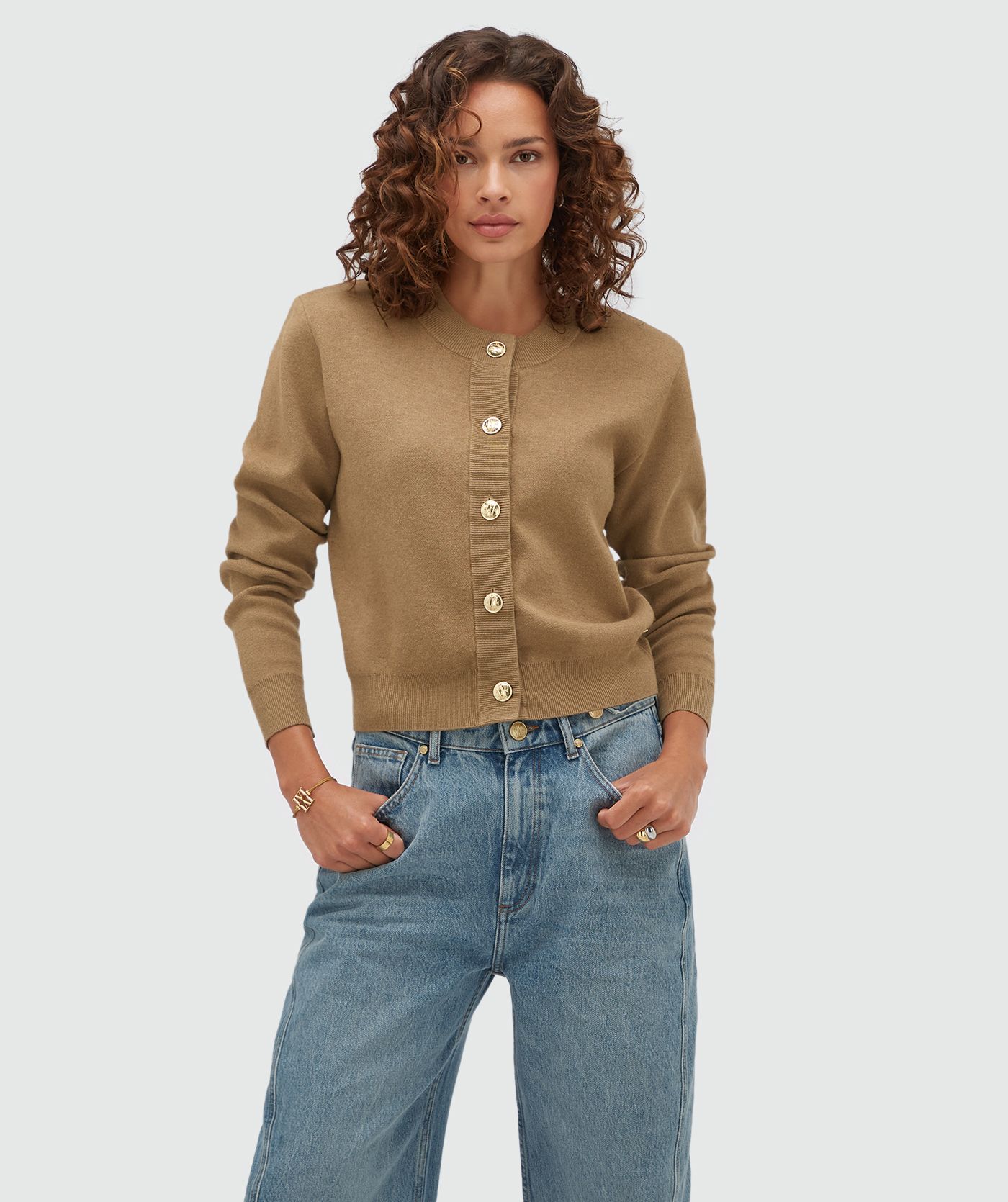 Model draagt een vest met gouden knopen in de kleur Khaki.