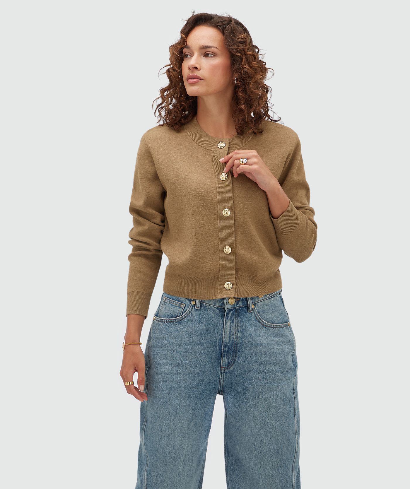 Model draagt een vest met gouden knopen in de kleur Khaki.