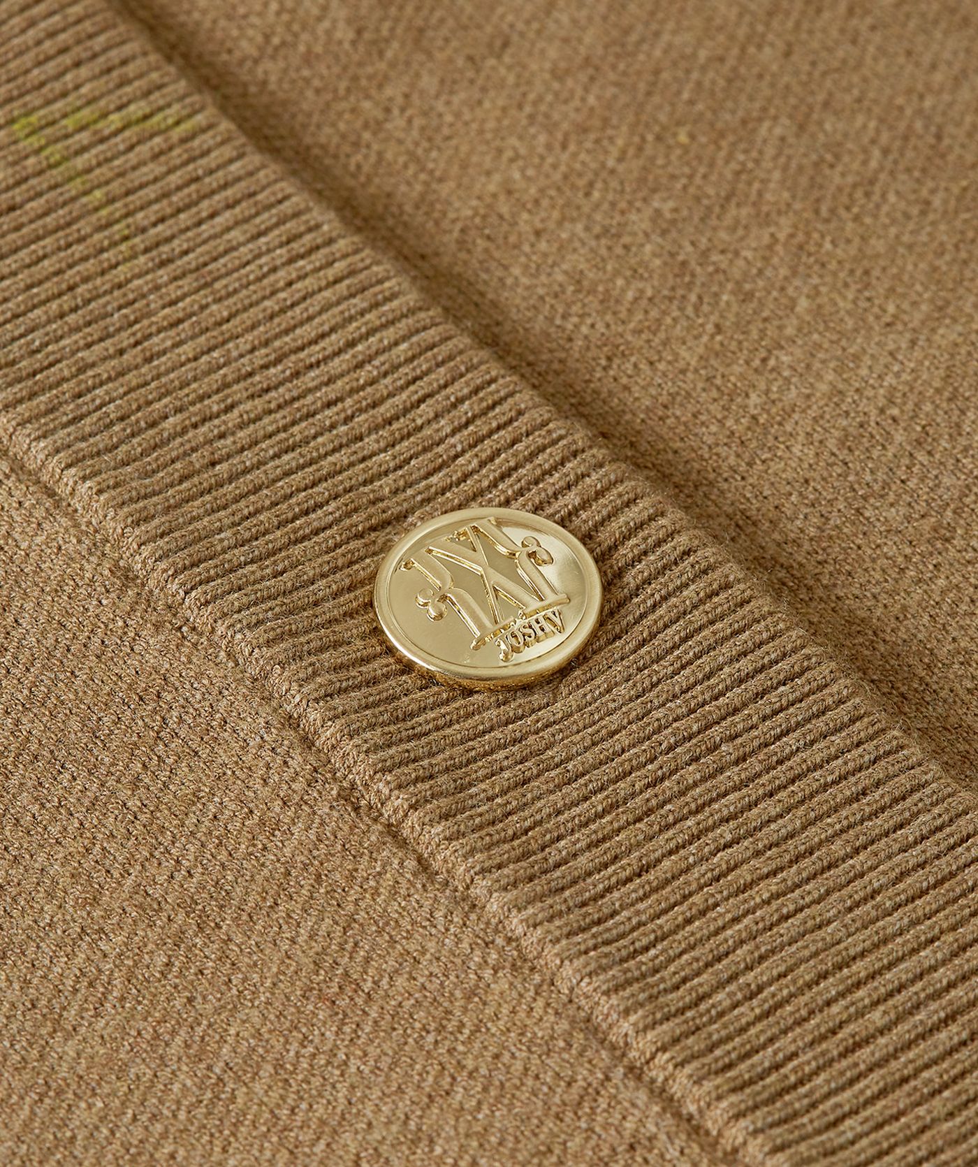 Close-up van de gouden knopen op het vest.