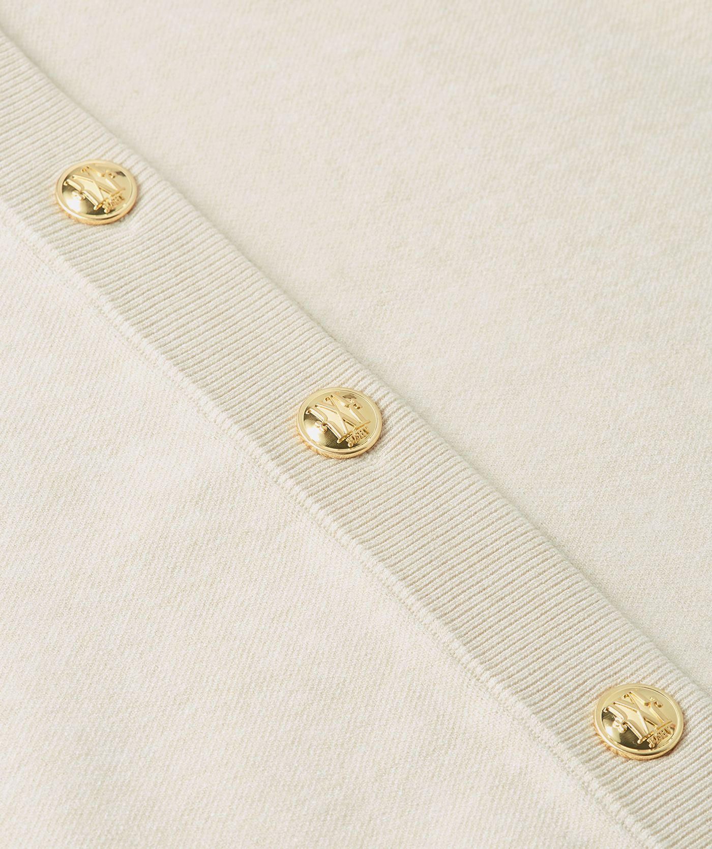 Close-up van gebroken wit vest met gouden knopen.
