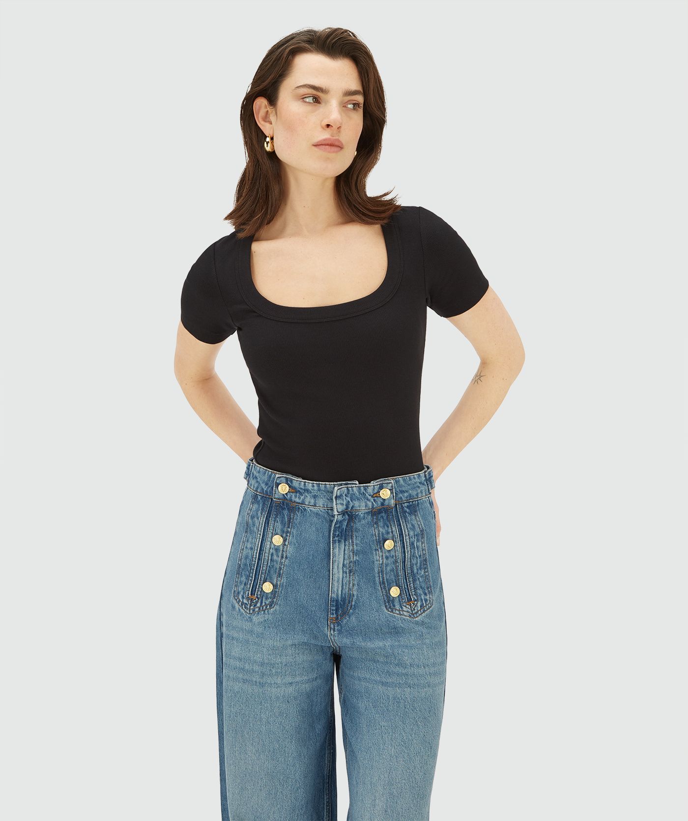 Model draagt een Zwarte top met korte mouwen en een vierkante hals 