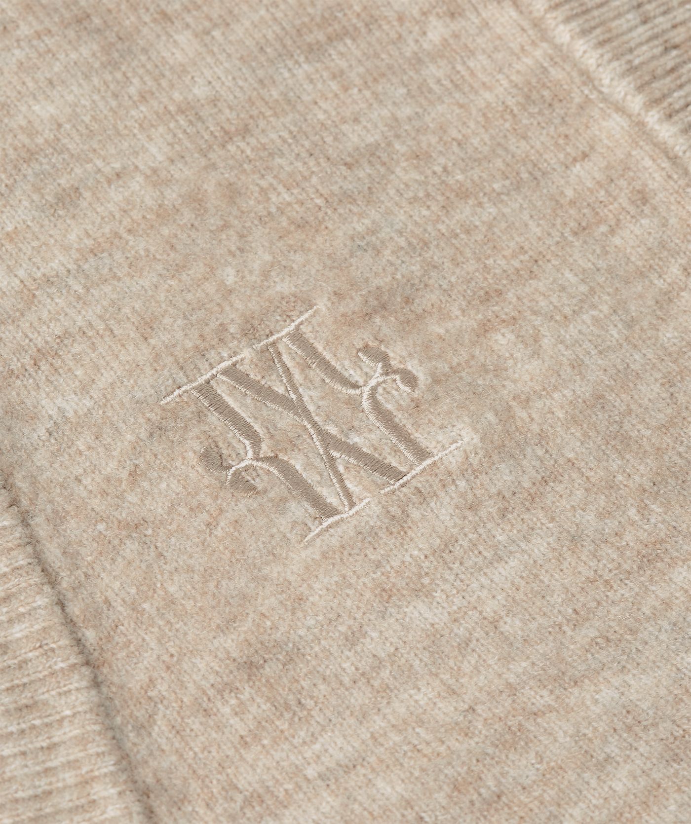 Close-up van JOSH V logo op het beige gilet.