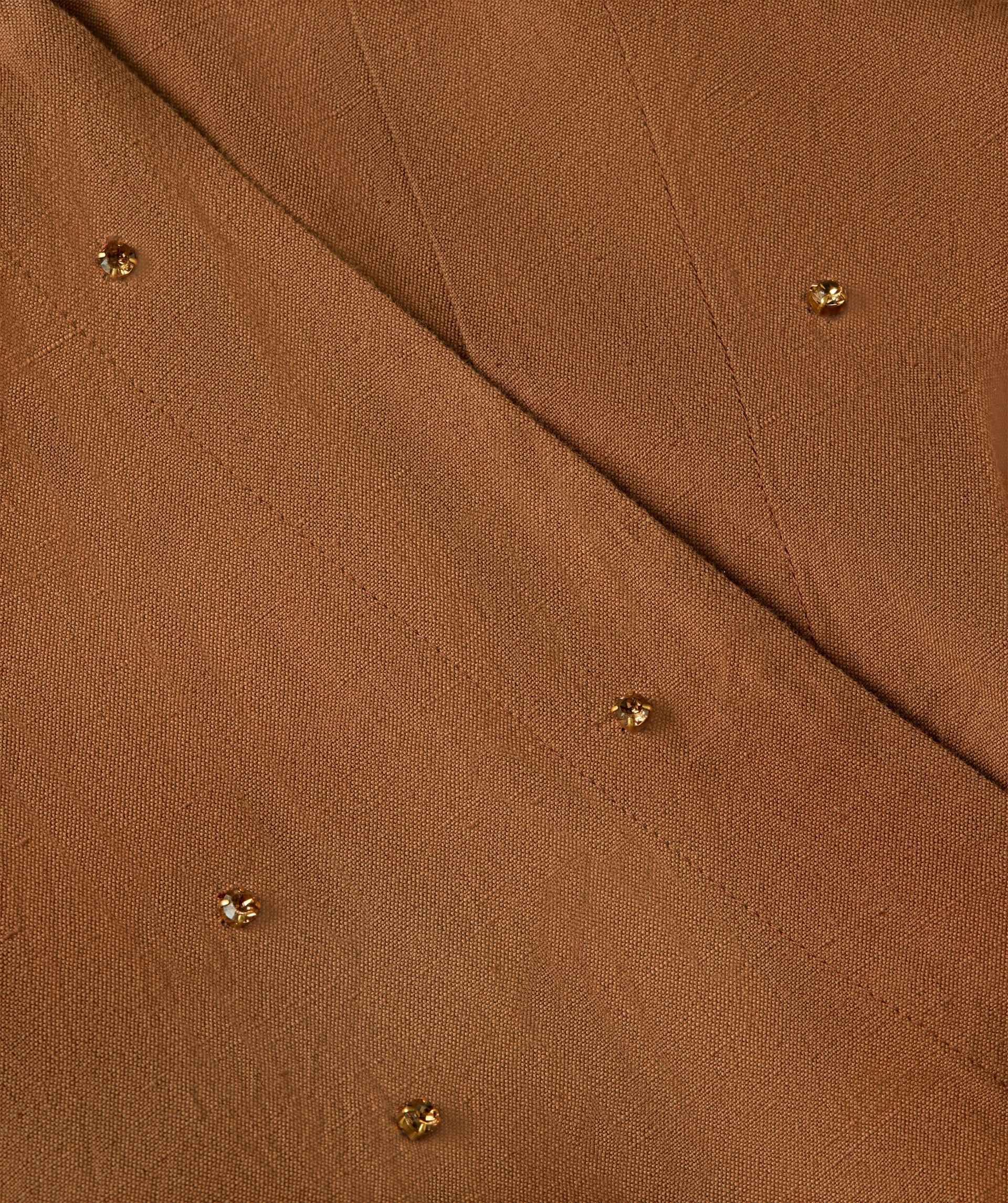 Close-up van sierstenen die op de voorkant avn de jurk zitten.