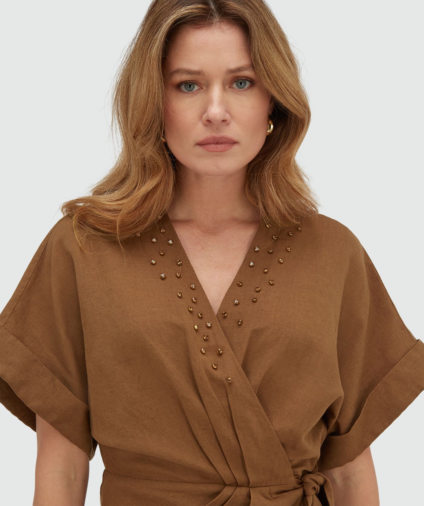 Model draagt een overslagjurk met sierstenen in de kleur Mocha Brown