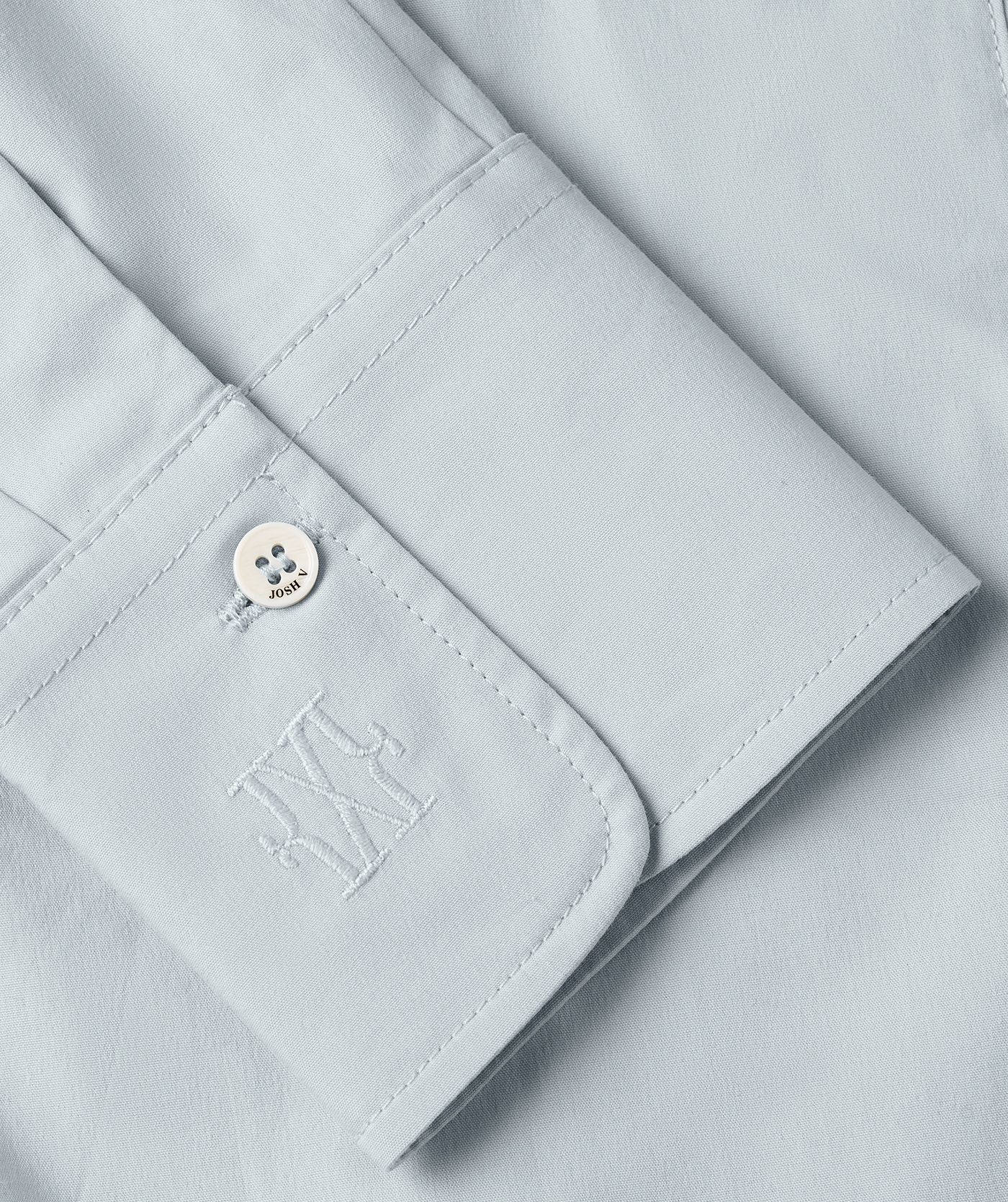 Close-up JOSH V branded knopen op mouw