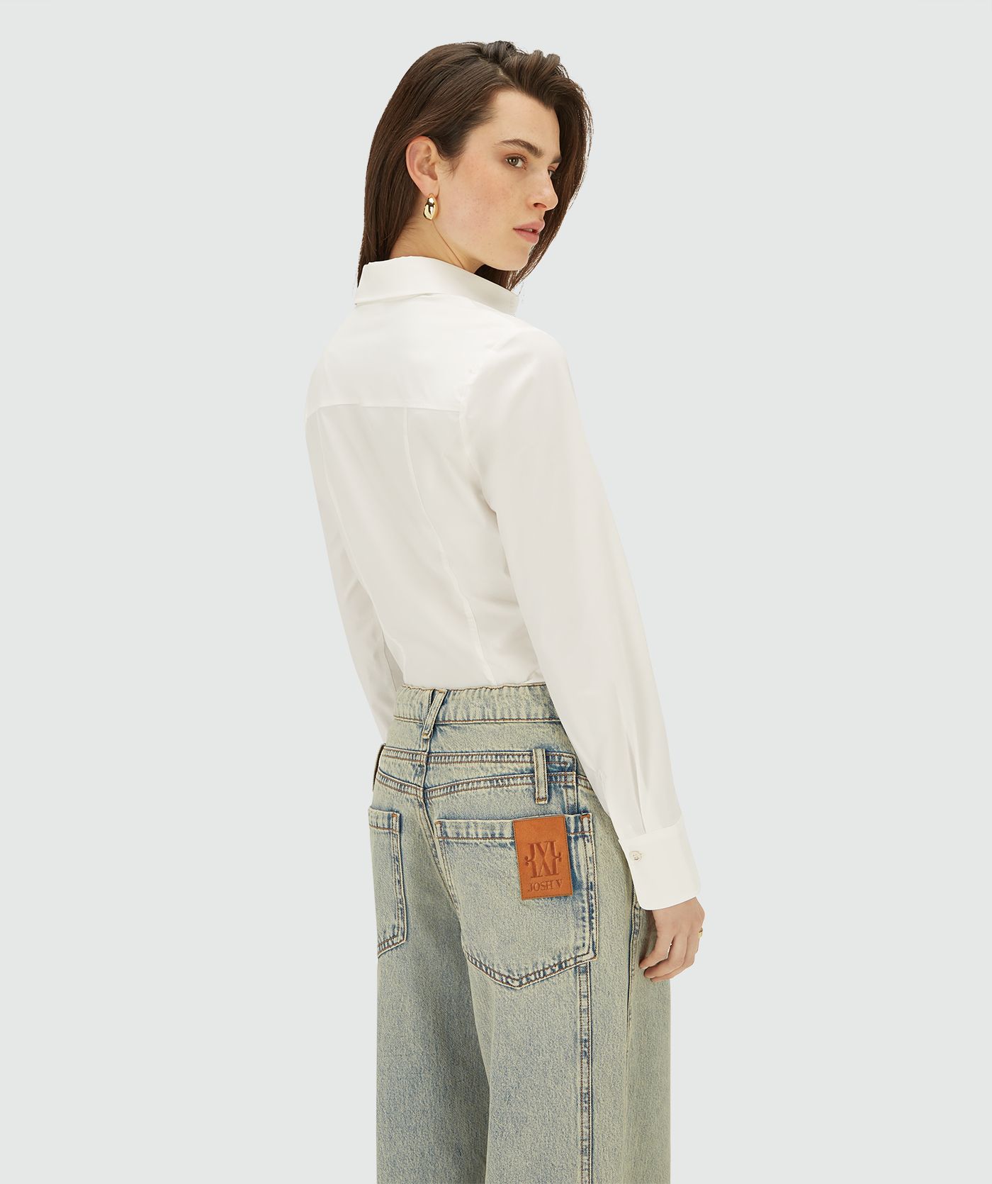 Achteraanzicht van model in een off white blouse